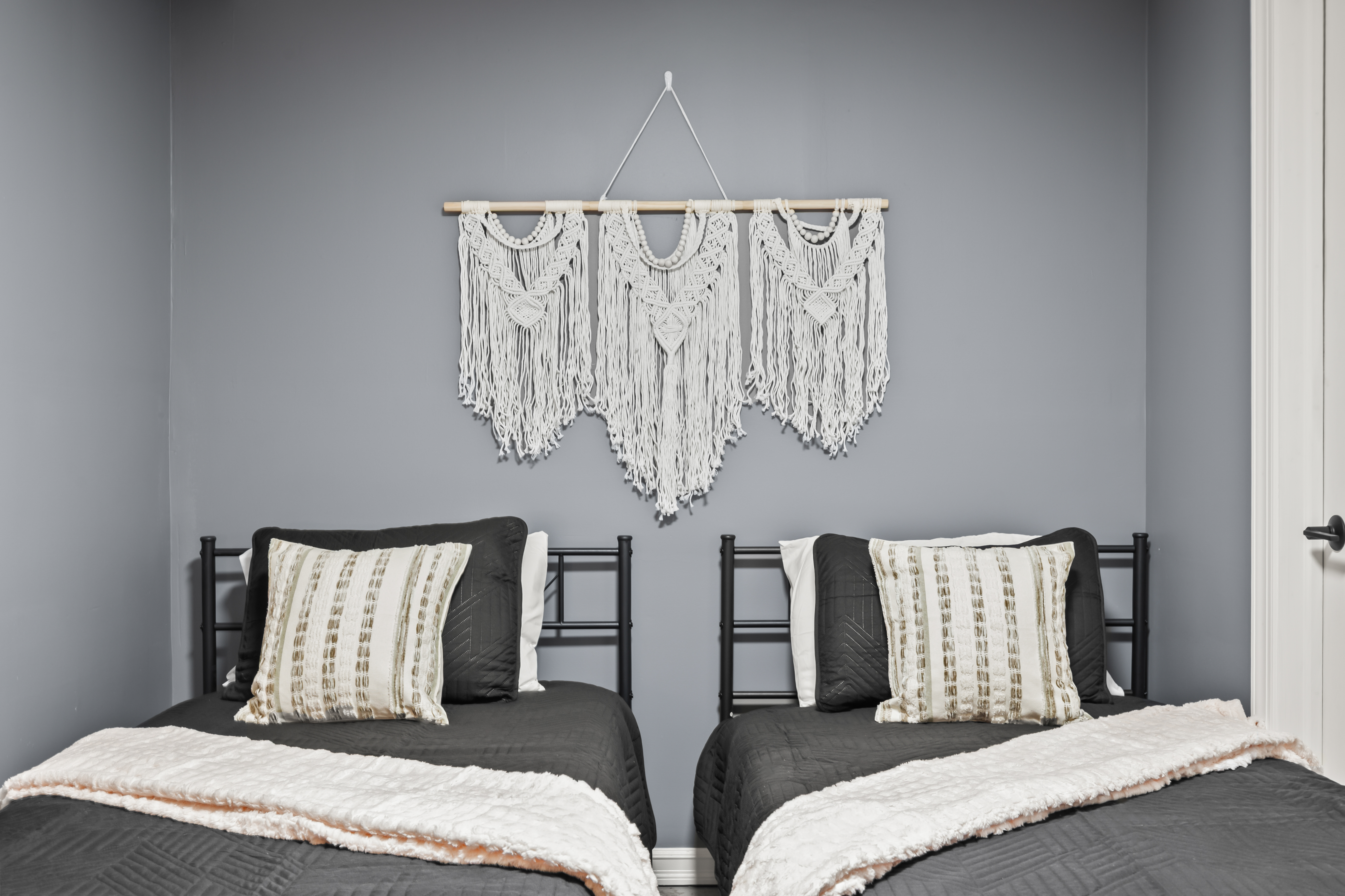 Cozy twin bedroom with modern styling and chic macramé wall décor