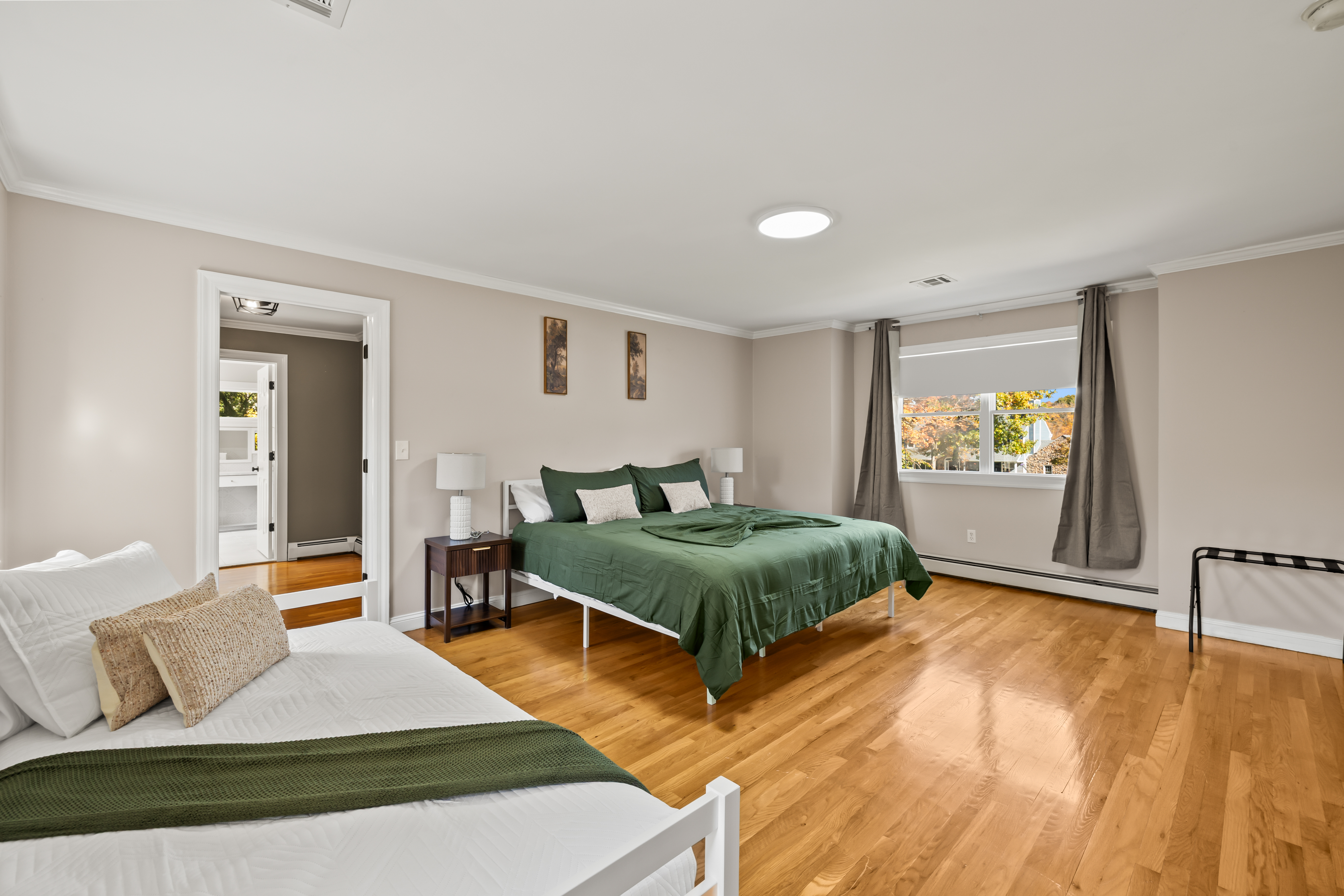 Spacious, sunlit bedroom with hardwood floors and flexible sleeping space