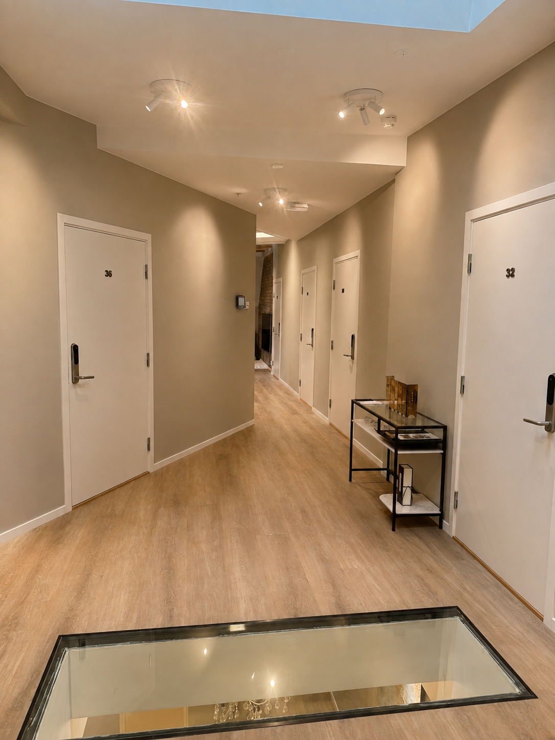 Modern, well-lit hallway with stylish finishes and a unique glass floor detail