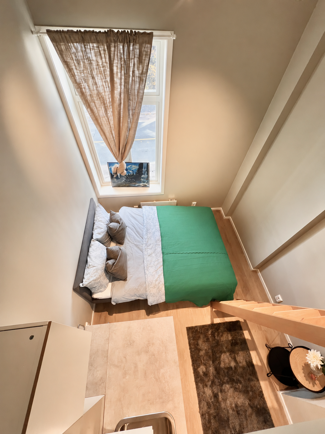 Cozy loft bedroom with skylight-style window and warm modern design