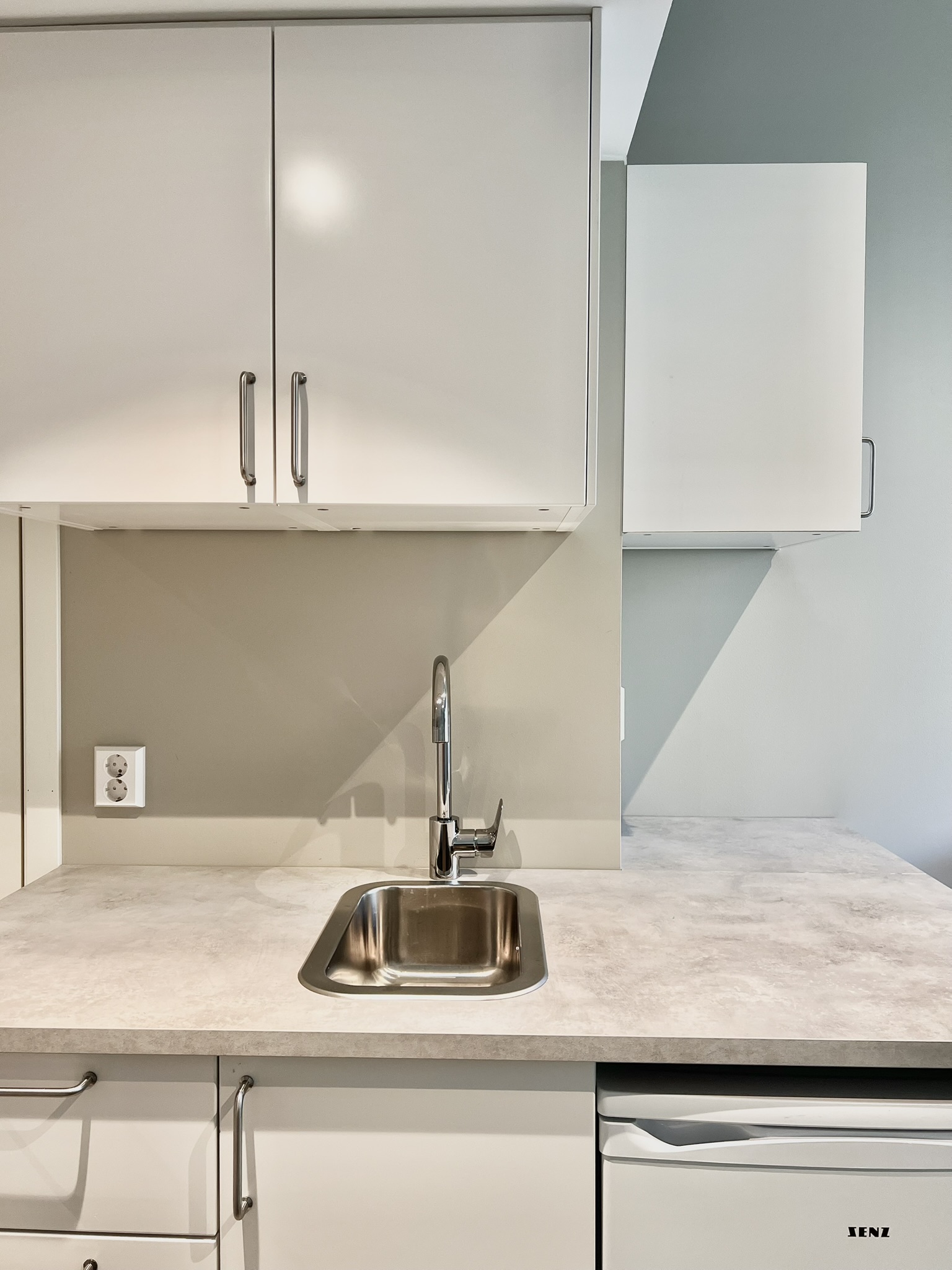 Bright modern kitchenette with sleek storage and practical prep space