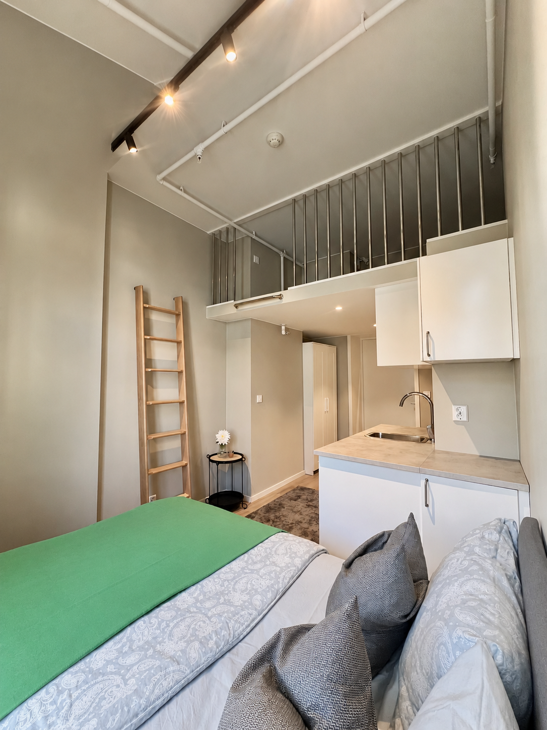 Modern loft studio with high ceilings and sleek kitchenette