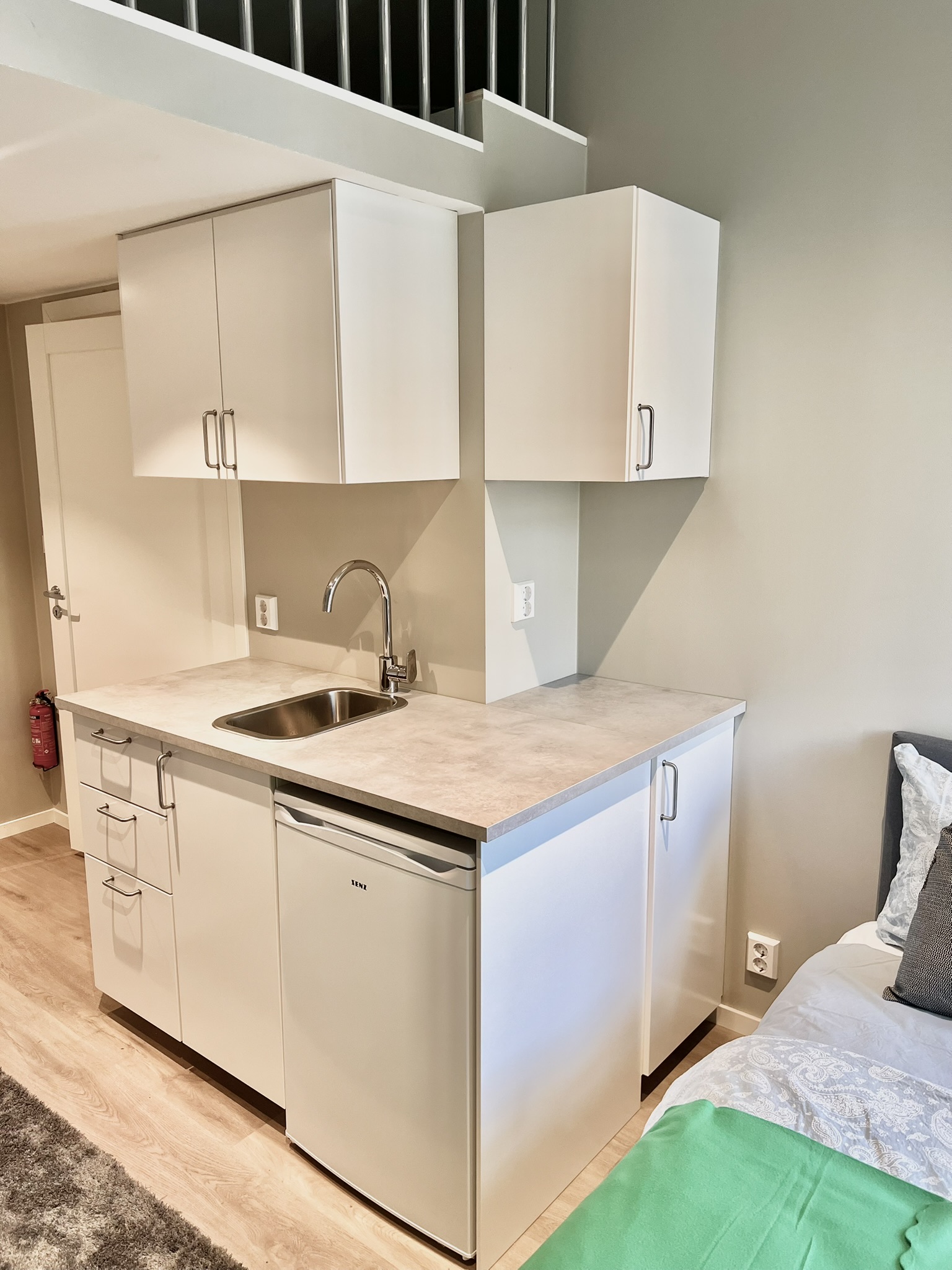 Bright modern kitchenette with mini fridge and sleek studio-style layout