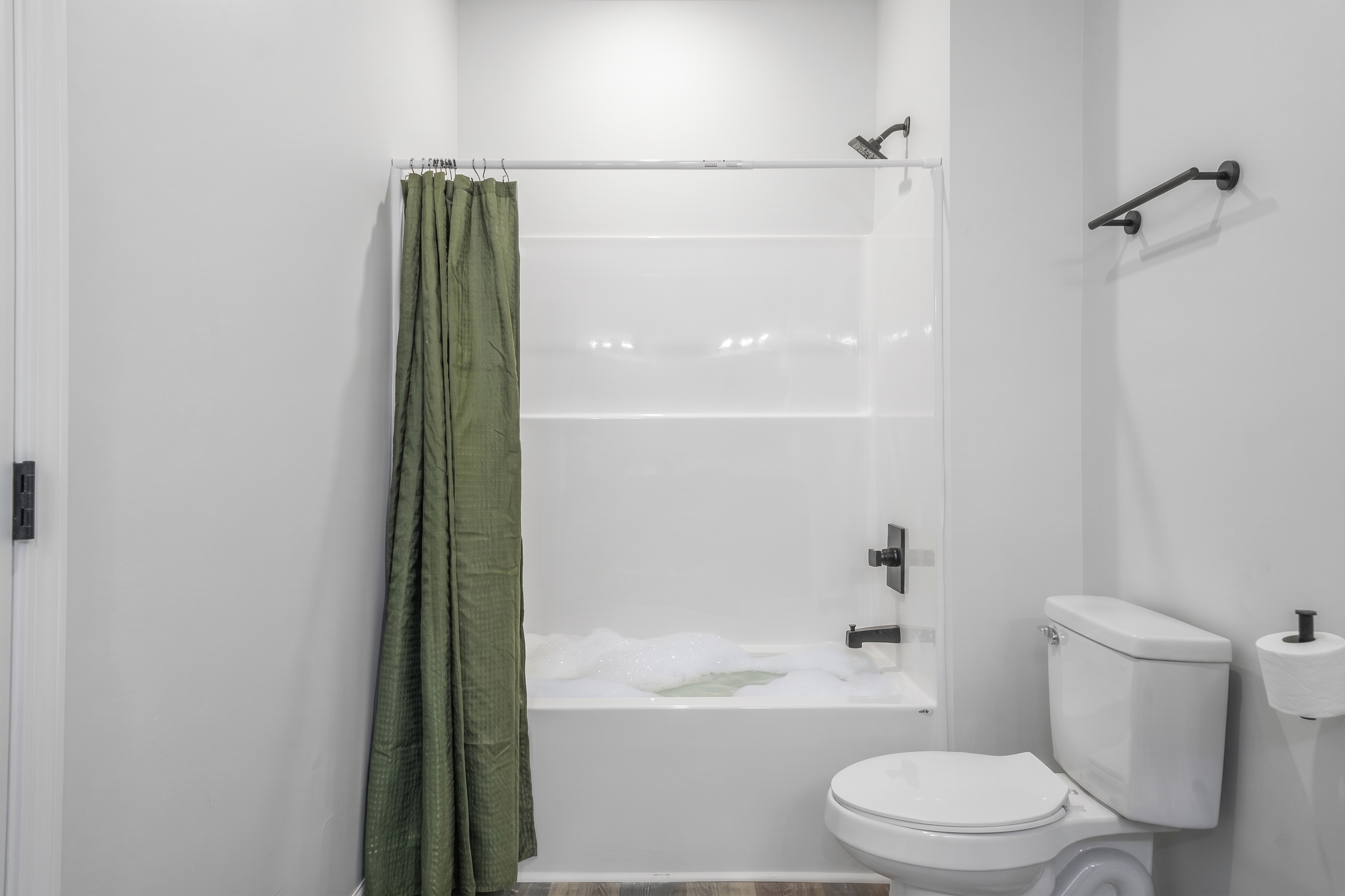 Bright modern bathroom with full tub-shower combo and clean finishes