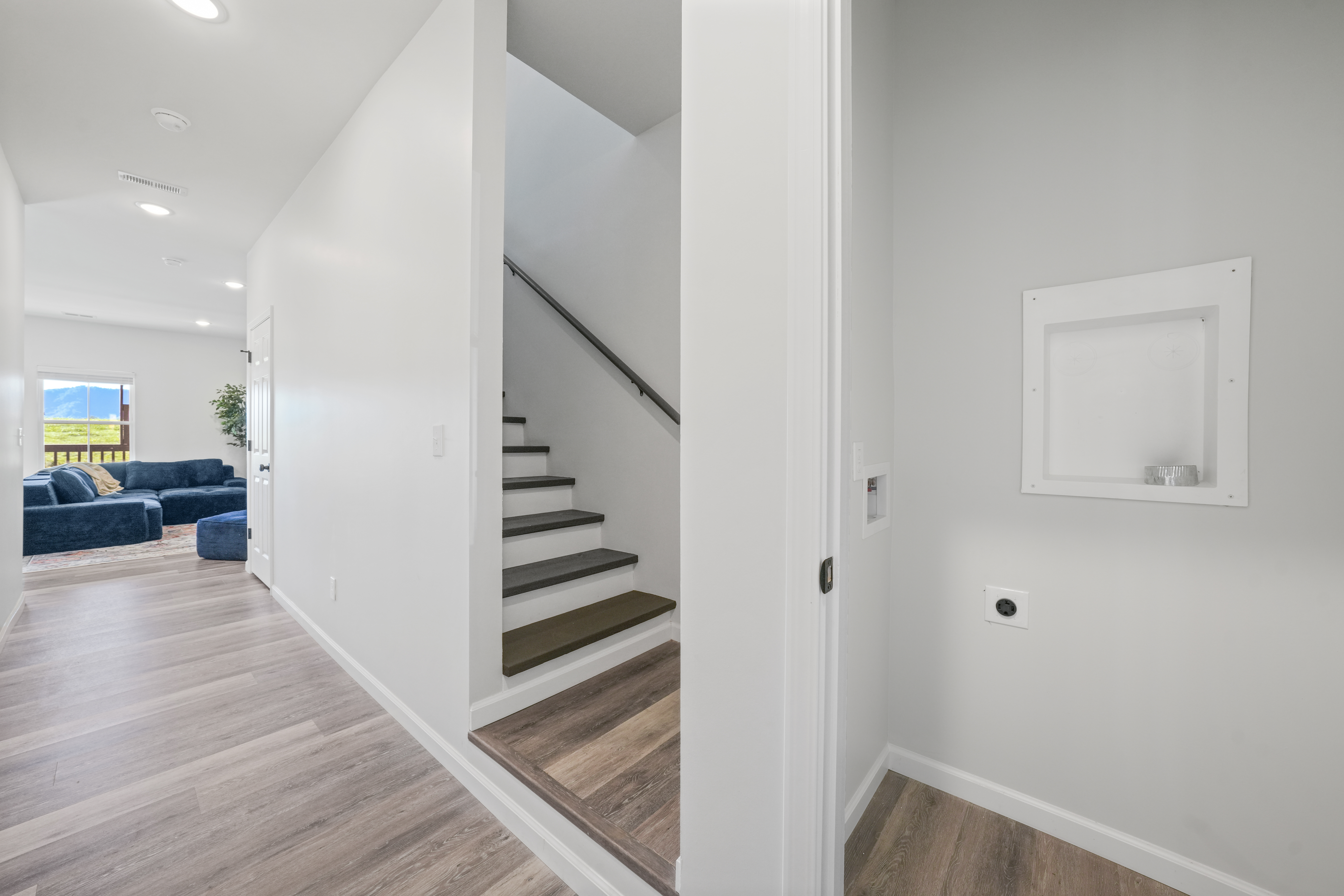 Bright modern entryway with sleek stairs and open living space