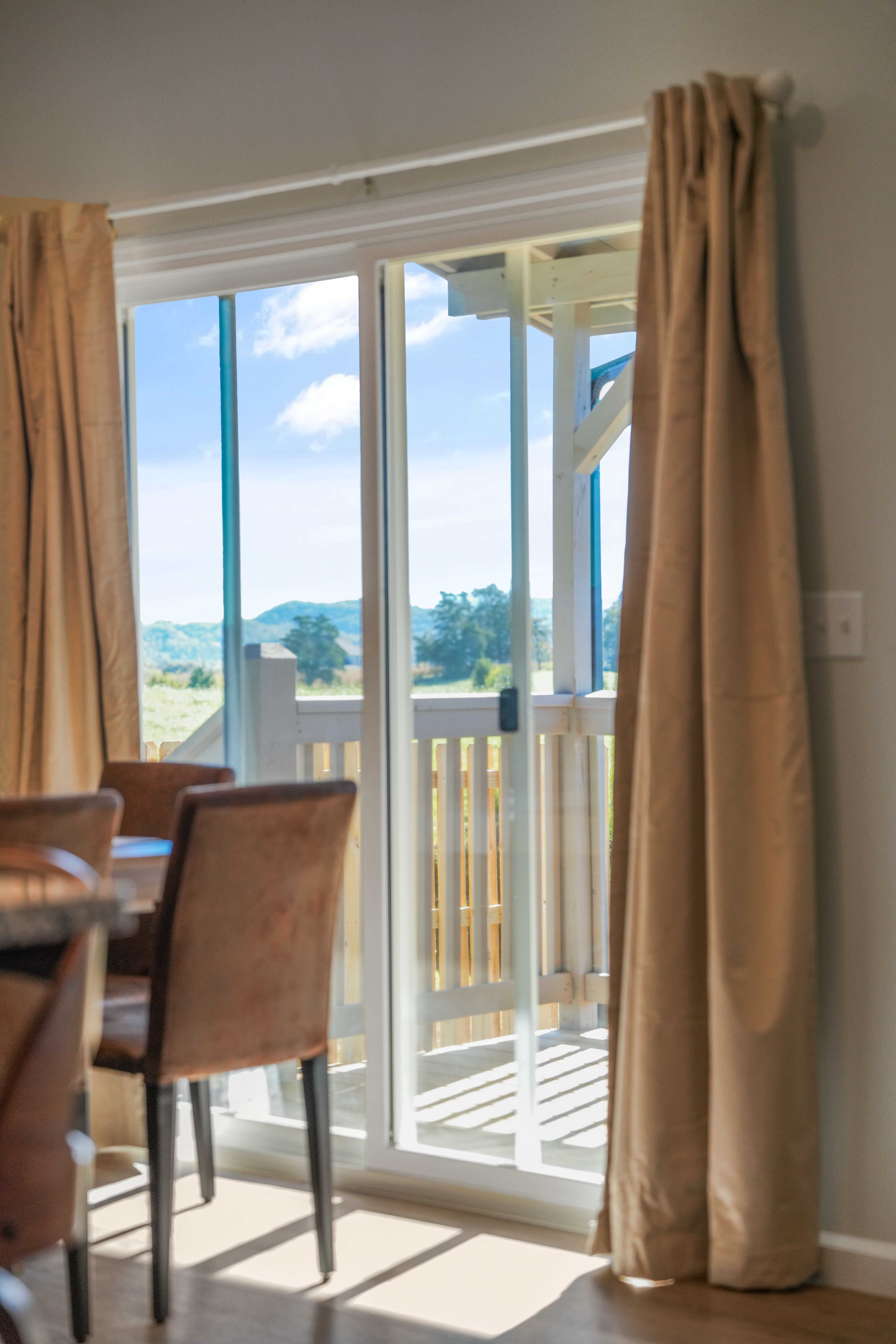 Bright dining area with balcony access and serene countryside views