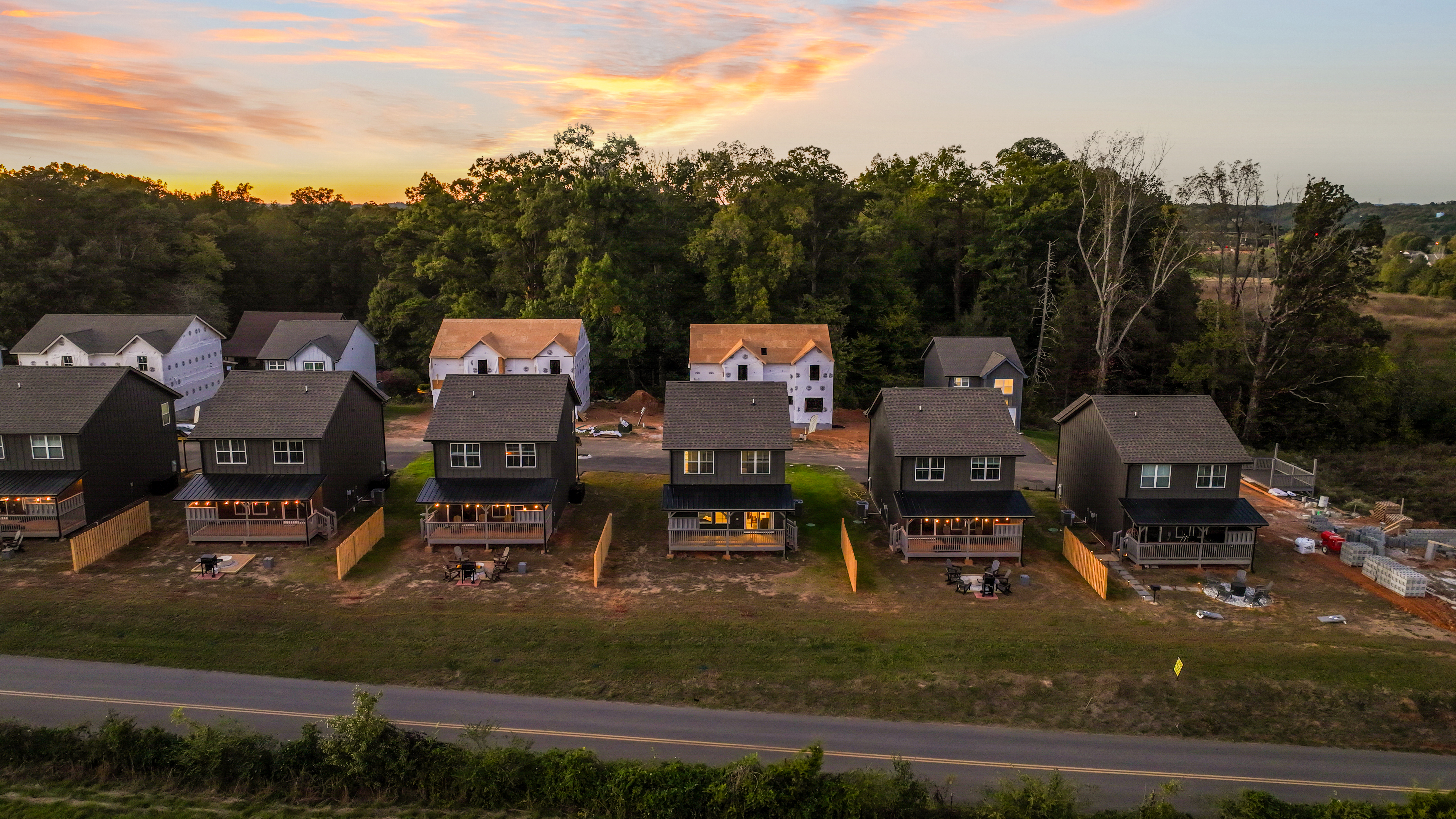 Twilight aerial of modern homes with decks and peaceful wooded views