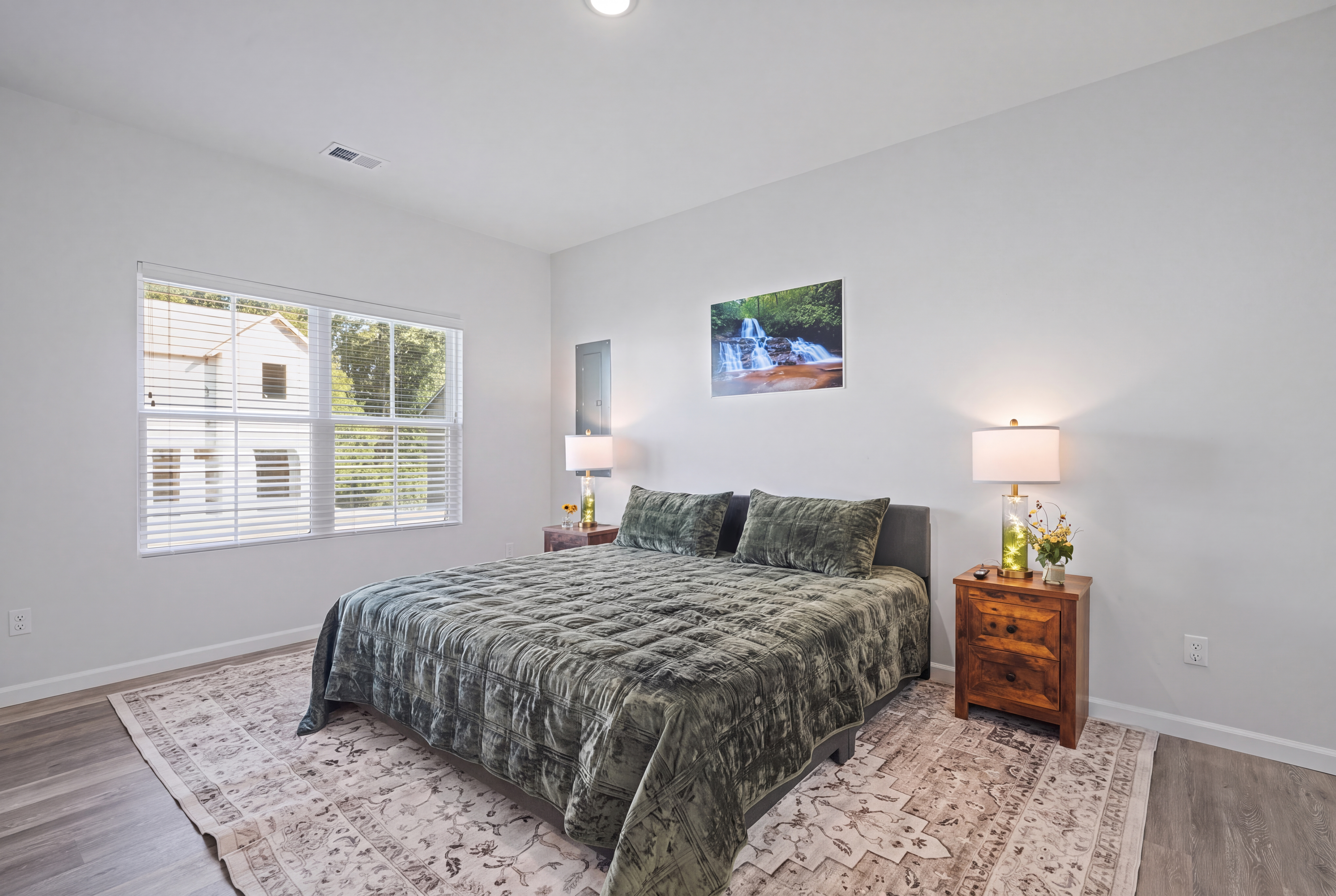 Bright, airy bedroom with plush king bed and warm bedside lighting