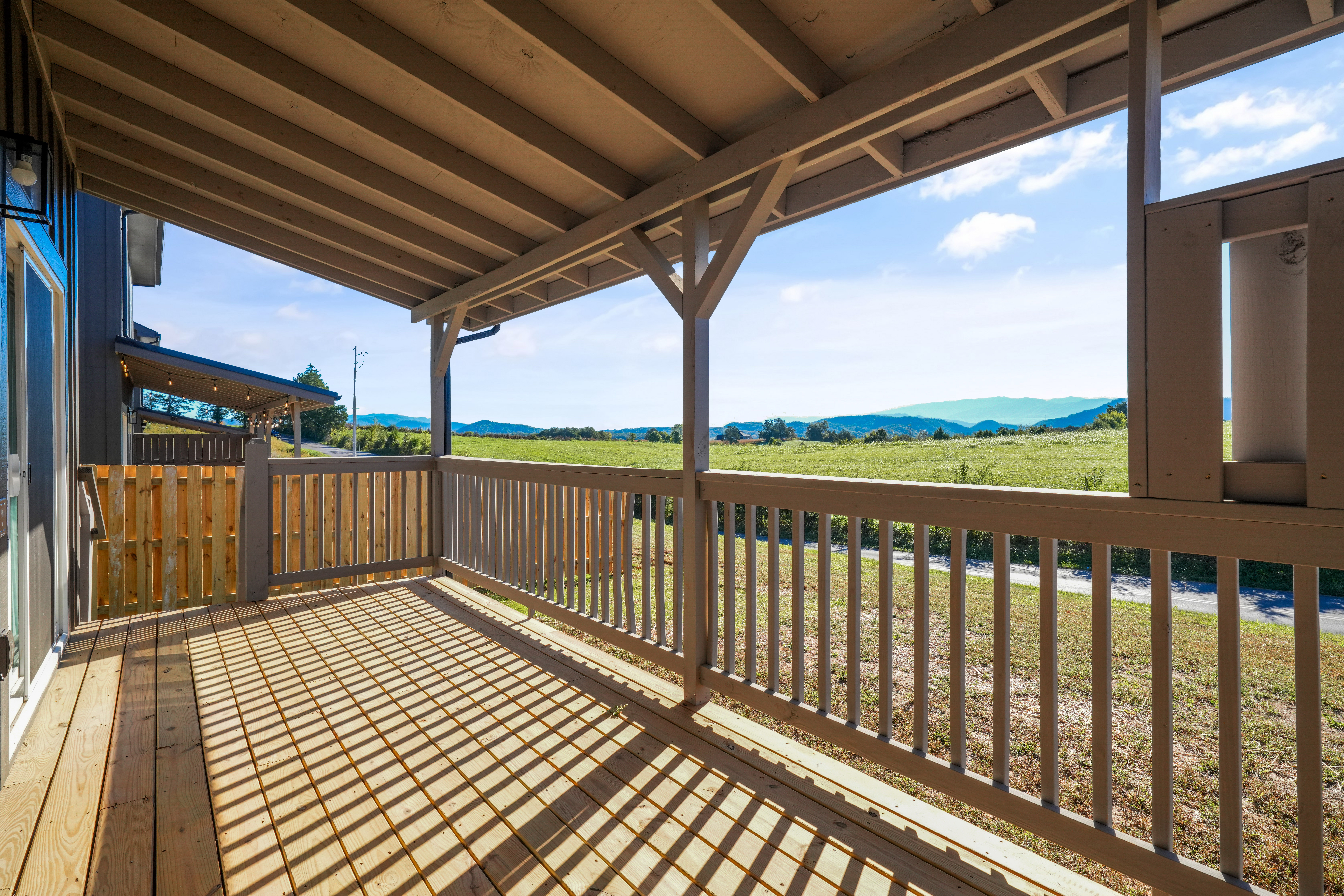 Covered porch with wide-open field views and peaceful mountain scenery