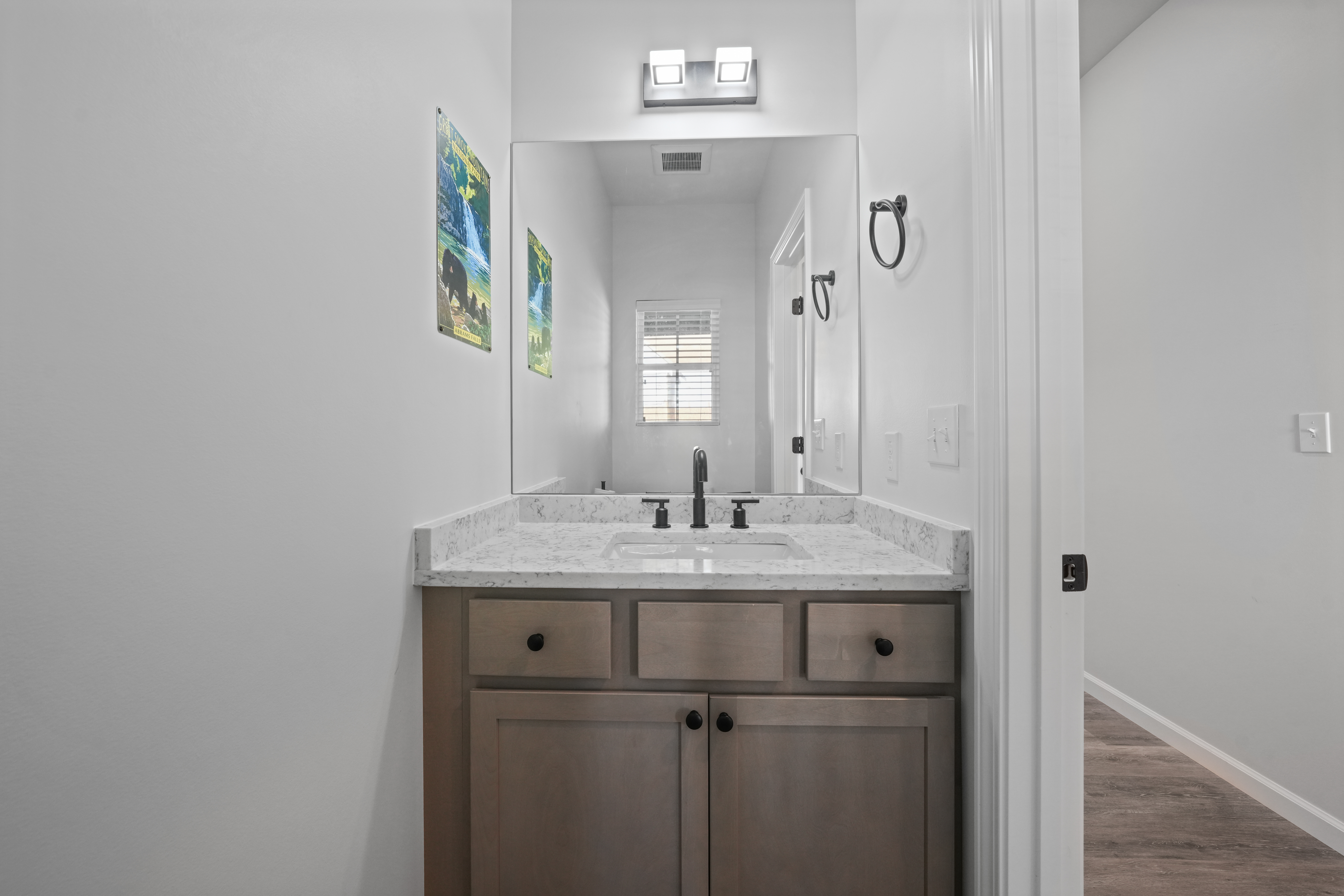 Bright modern vanity with marble-look counters and stylish black fixtures