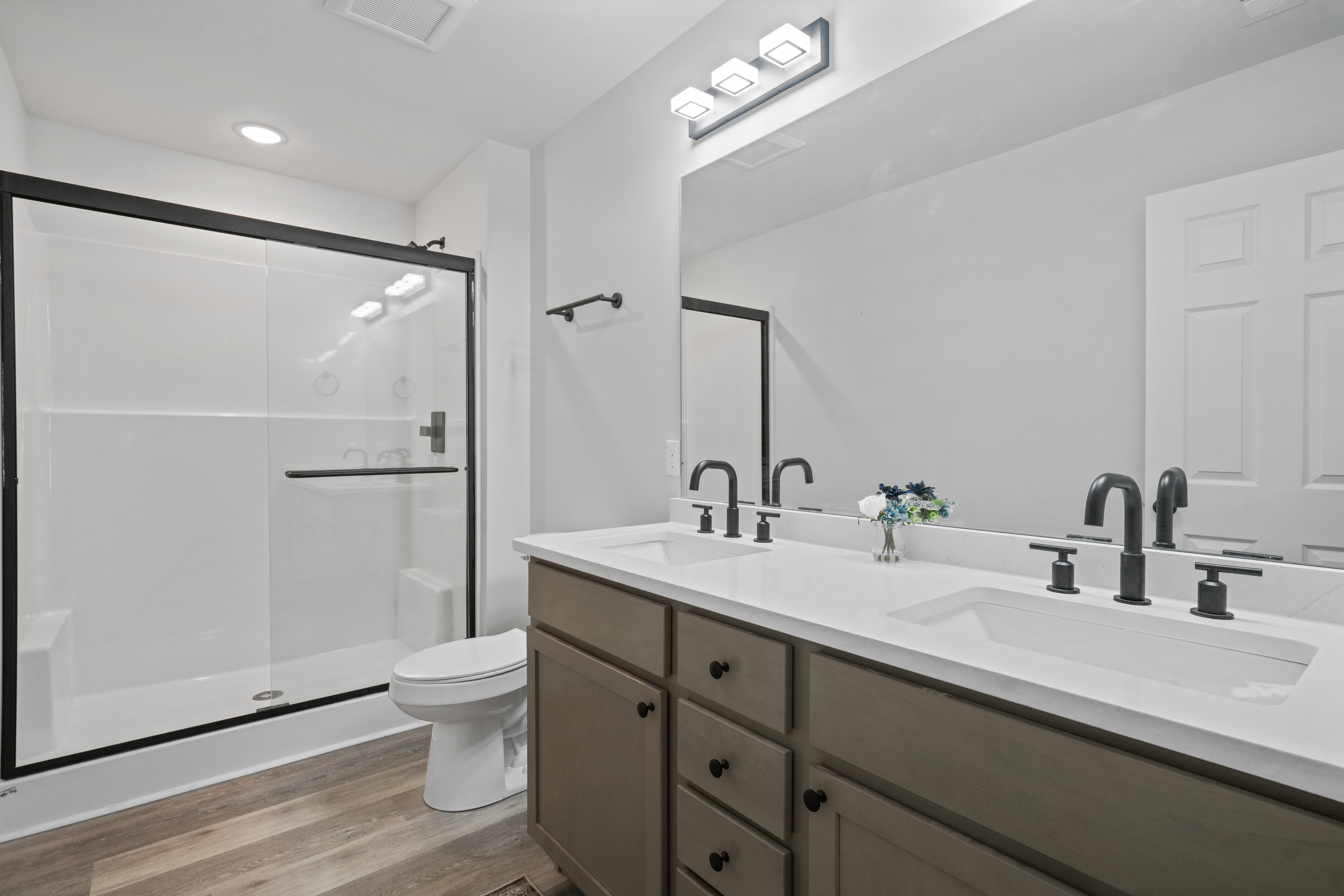 Modern bath with double vanity and sleek glass walk-in shower