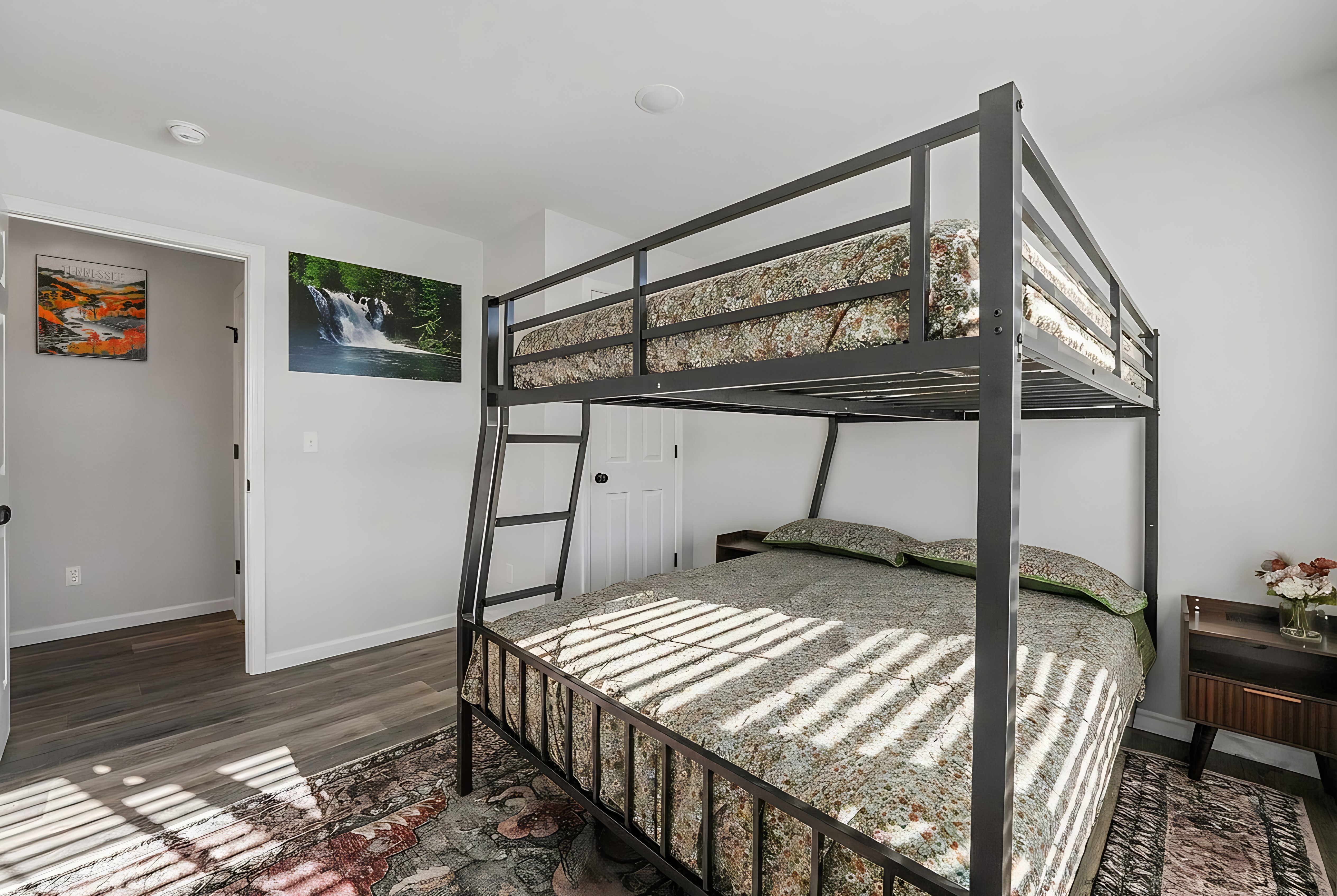 Bright bunk room with queen bed, top bunk, and stylish cozy touches