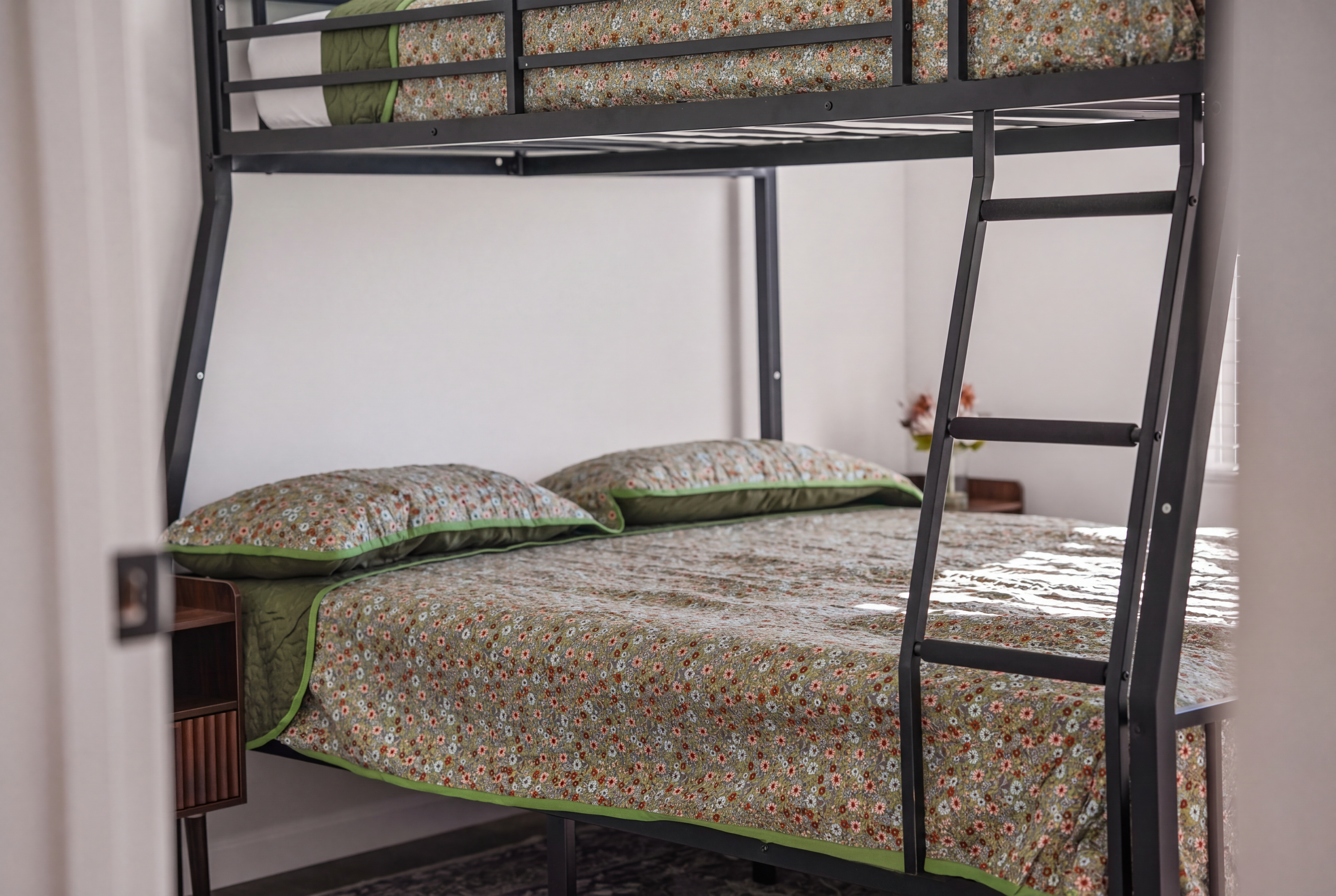 Family-friendly bunk room with full lower bed and cozy floral bedding