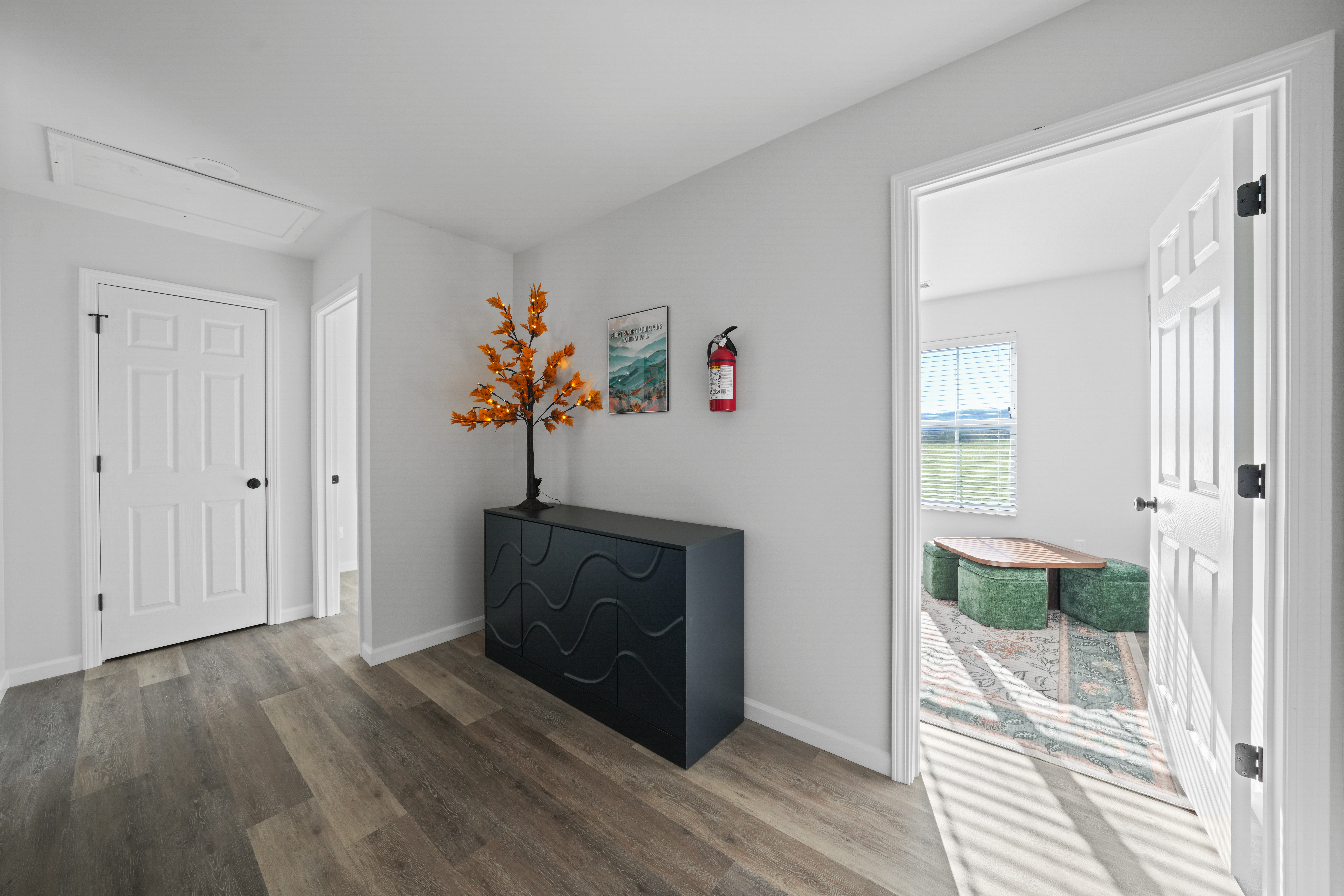 Bright modern hallway with stylish accents and sunlit adjoining room