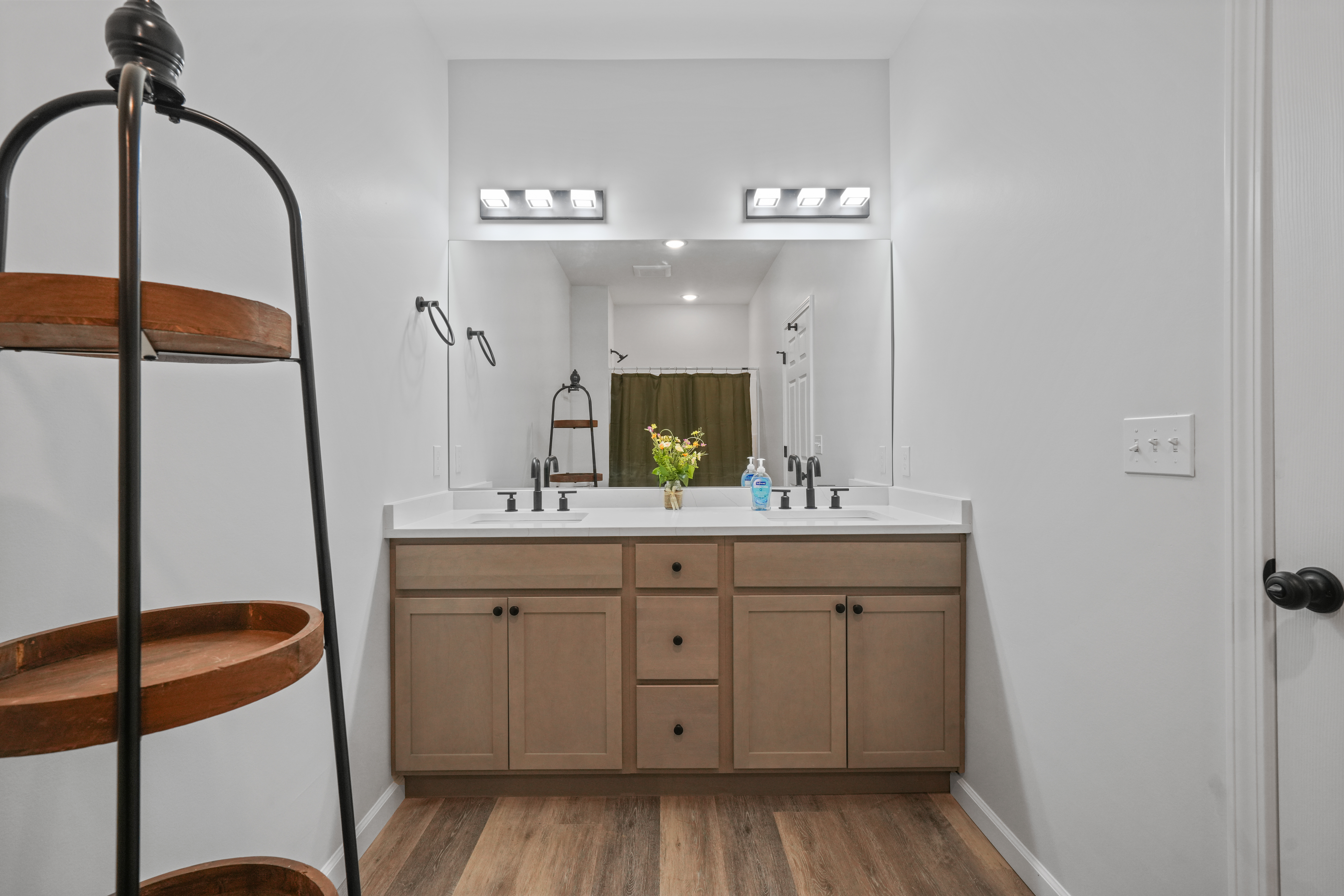 Spacious double vanity with modern finishes and warm wood accents