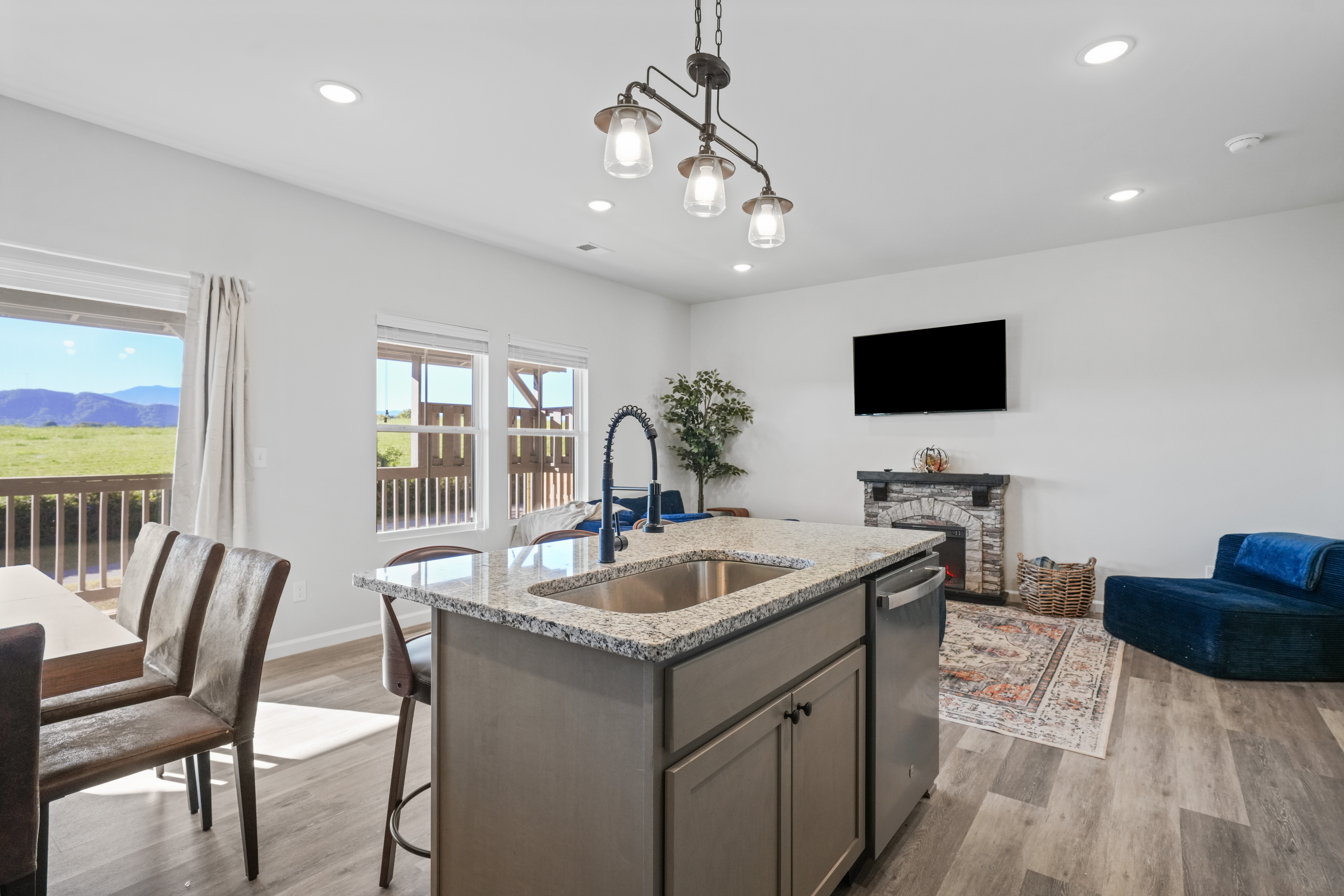 Bright open living space with mountain views, fireplace, and modern kitchen