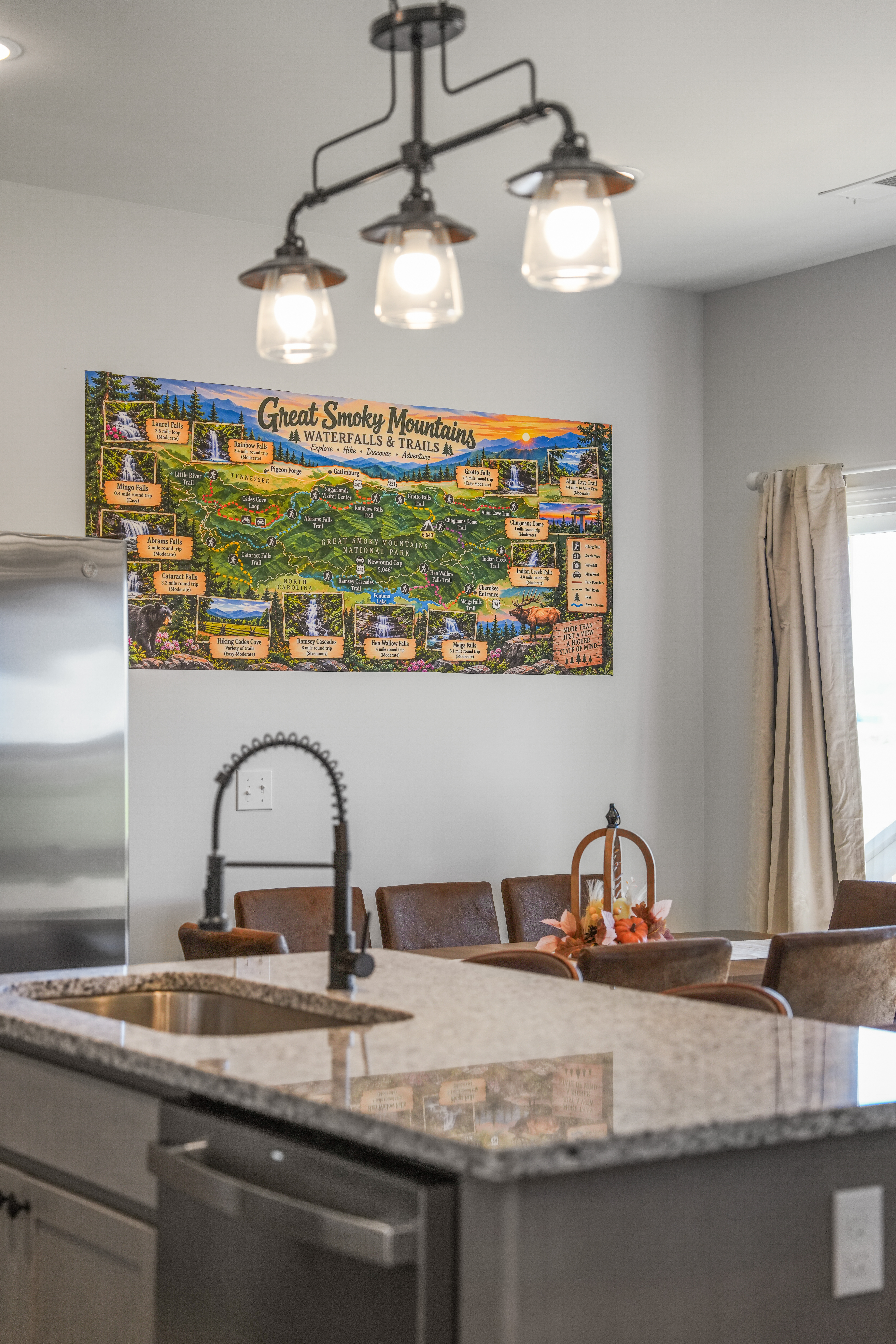 Bright kitchen with granite island, stylish lighting, and Smoky Mountain charm
