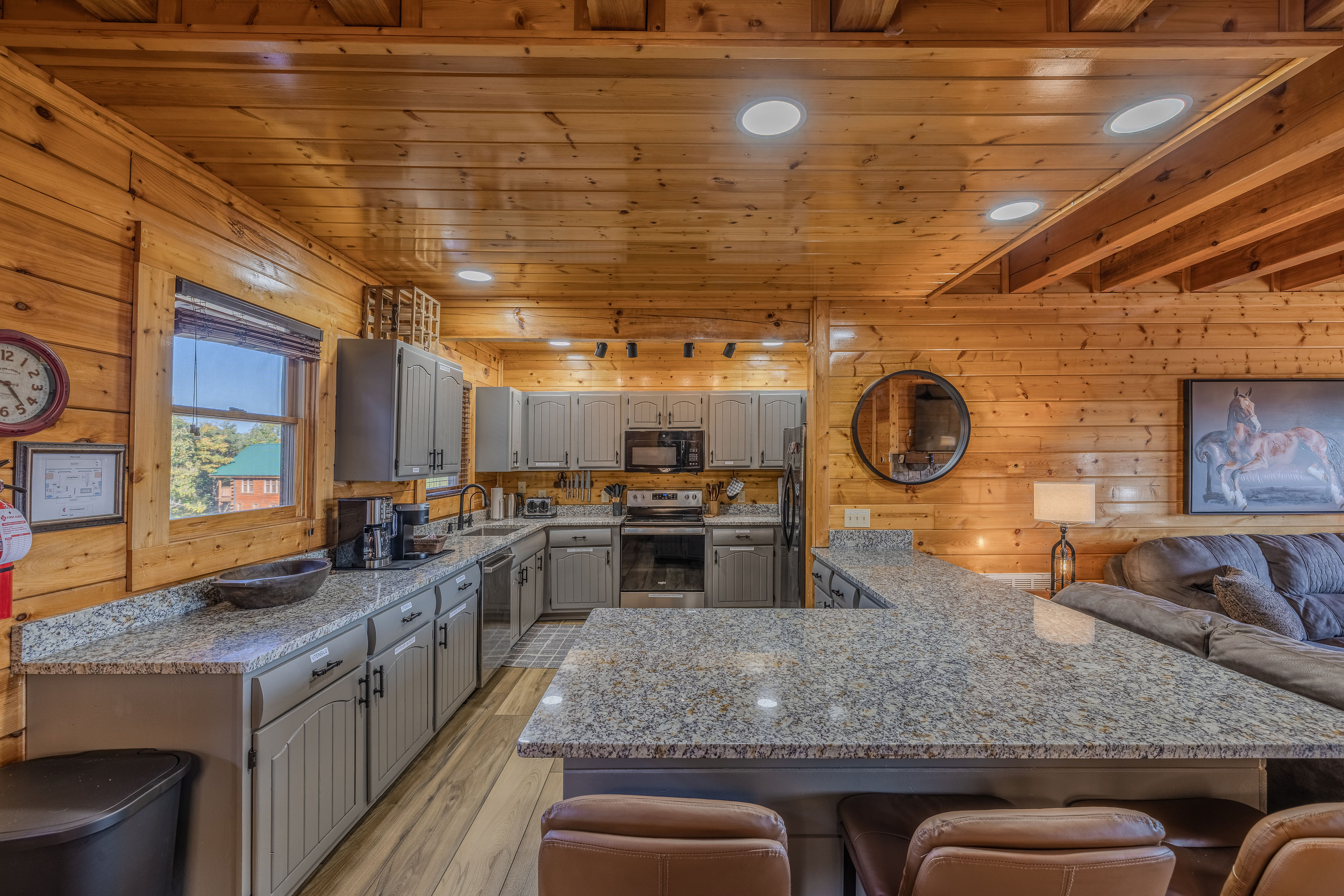 Warm cabin kitchen with granite island, bar seating, and cozy open layout