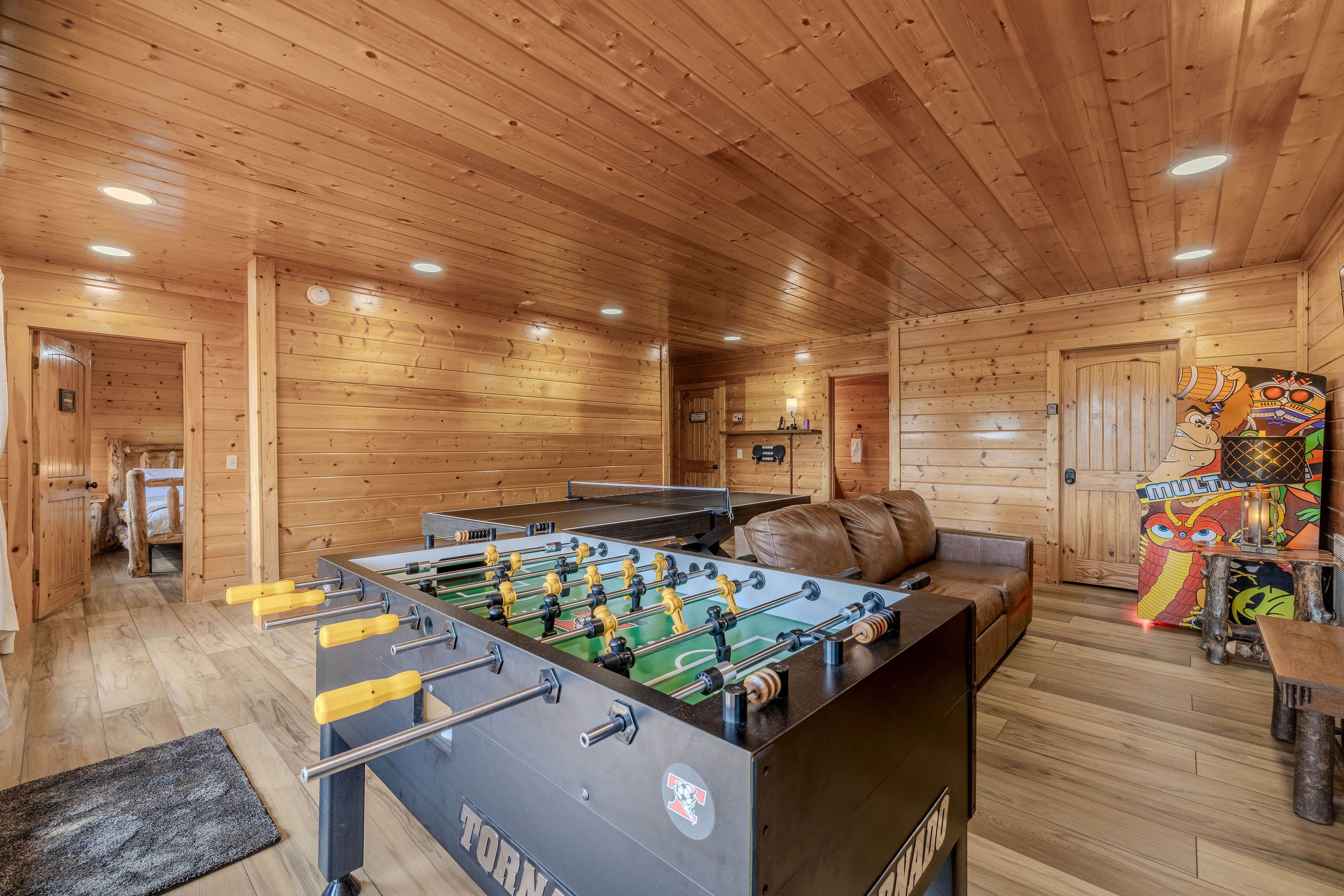 Cozy cabin game room withTornado foosball, ping pong, arcade fun, and lounge seating