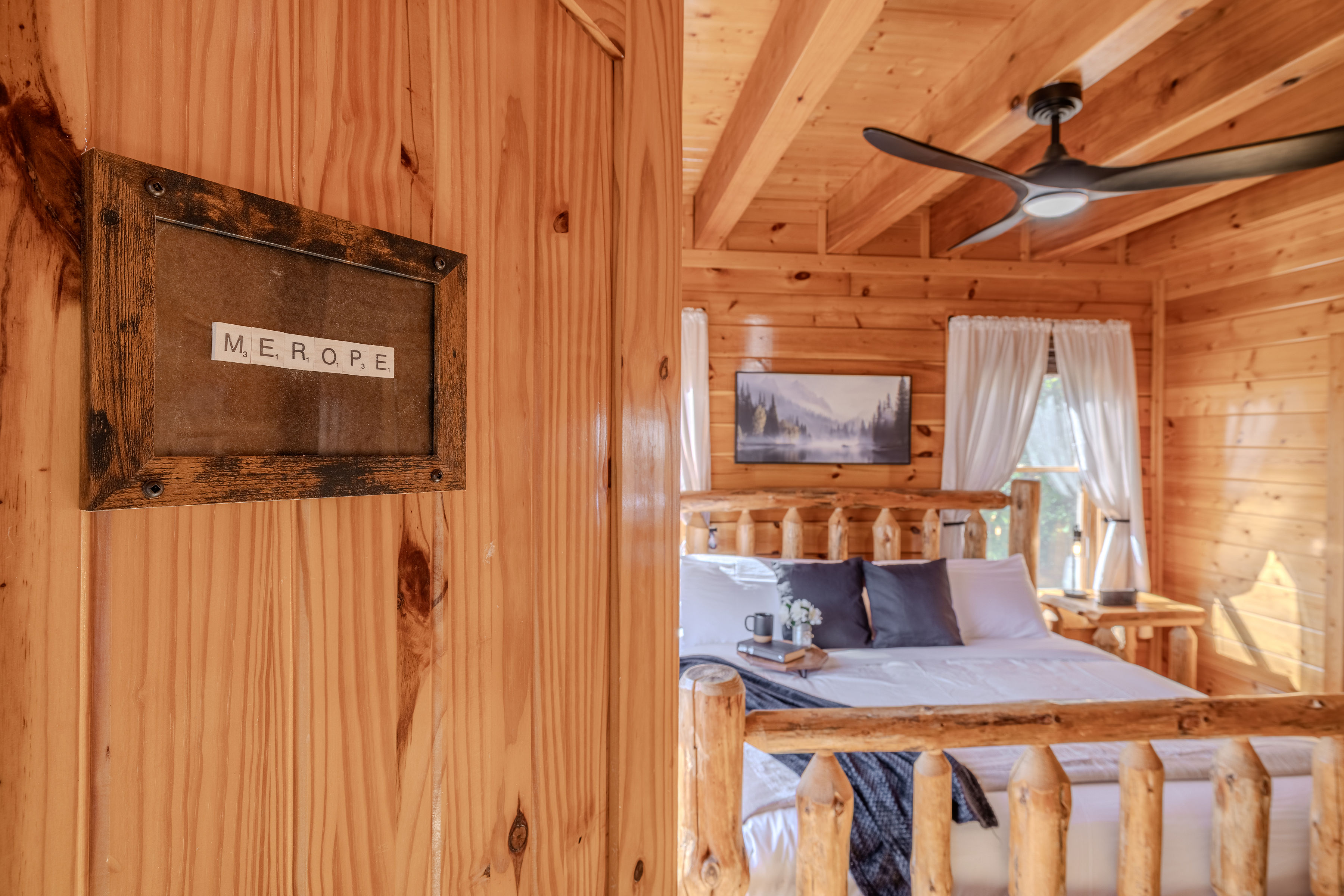 MEROPE Cozy King suite bedroom with warm wood interiors and charming cabin style, middle floor right side off living room