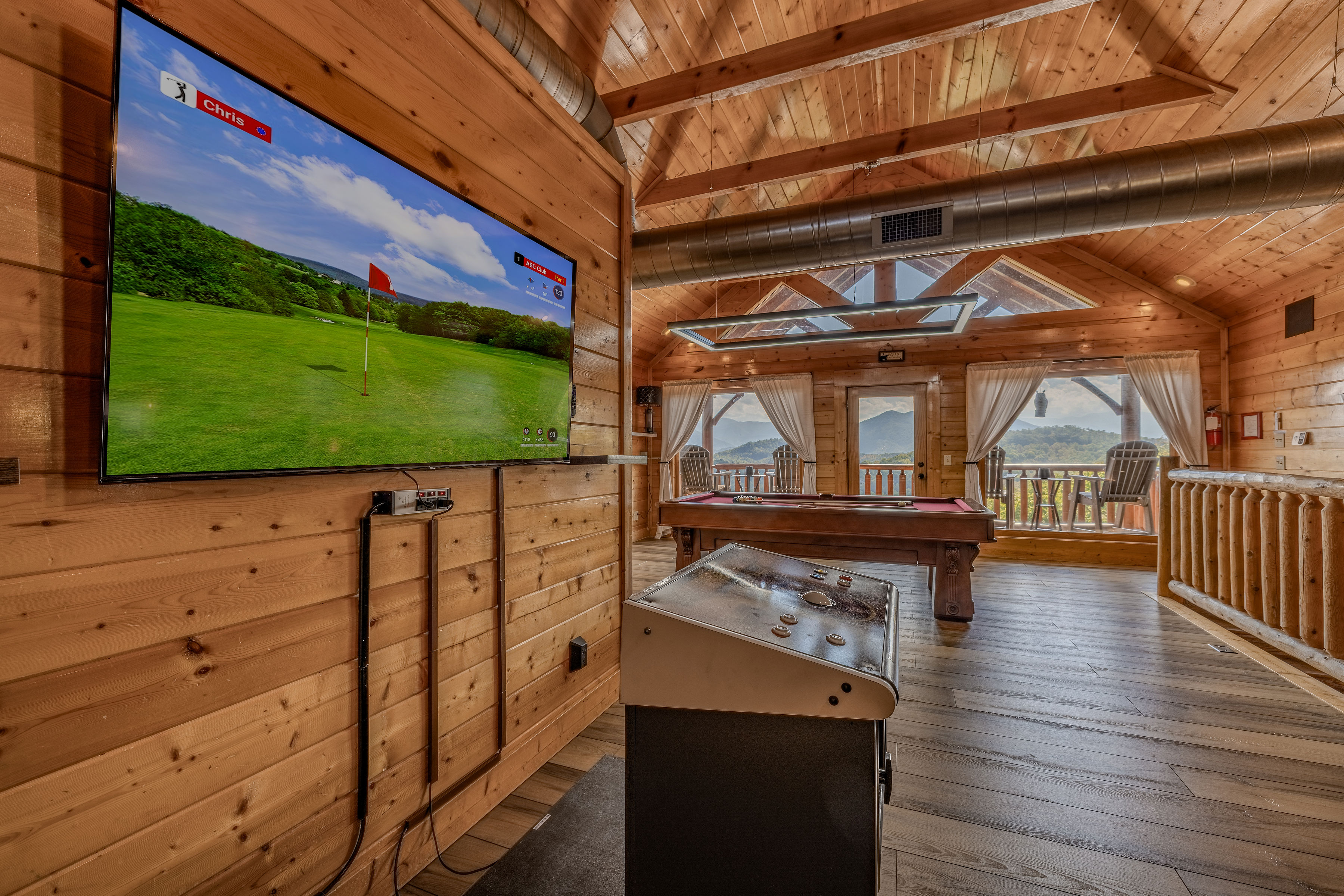 Rustic game loft with Golden Tee Golf game, pool table, and mountain-view balcony