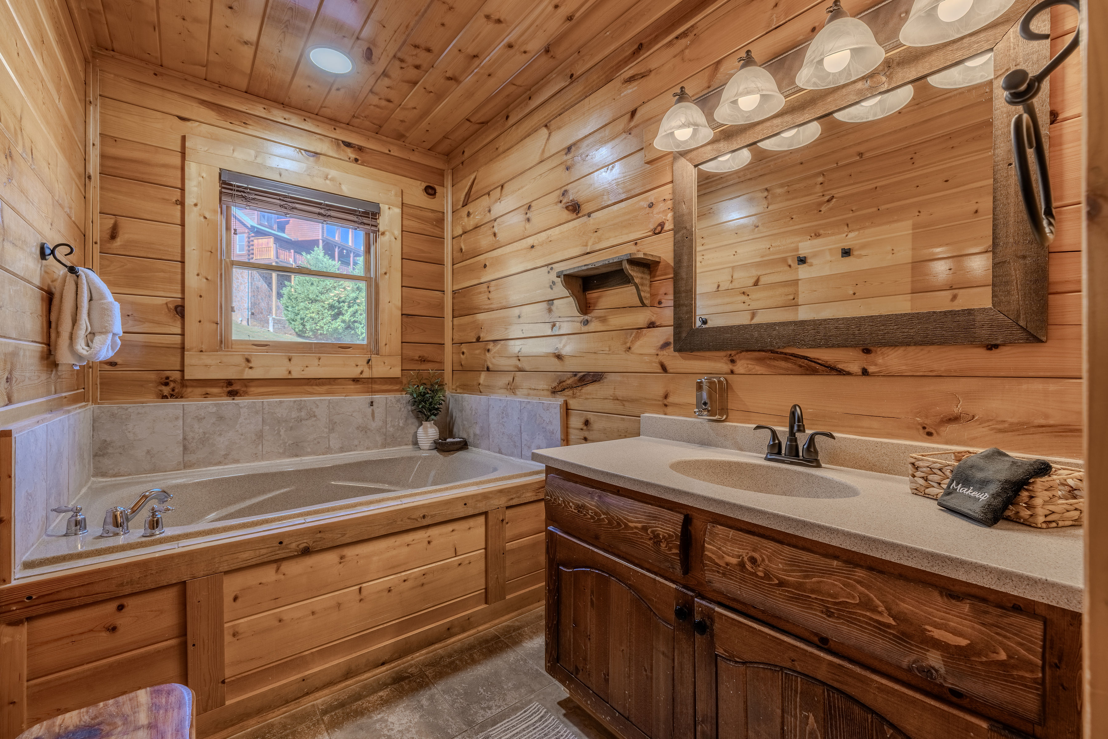 MAIA Rustic cabin bathroom with jetted soaking tub, walk in shower and roomy vanity