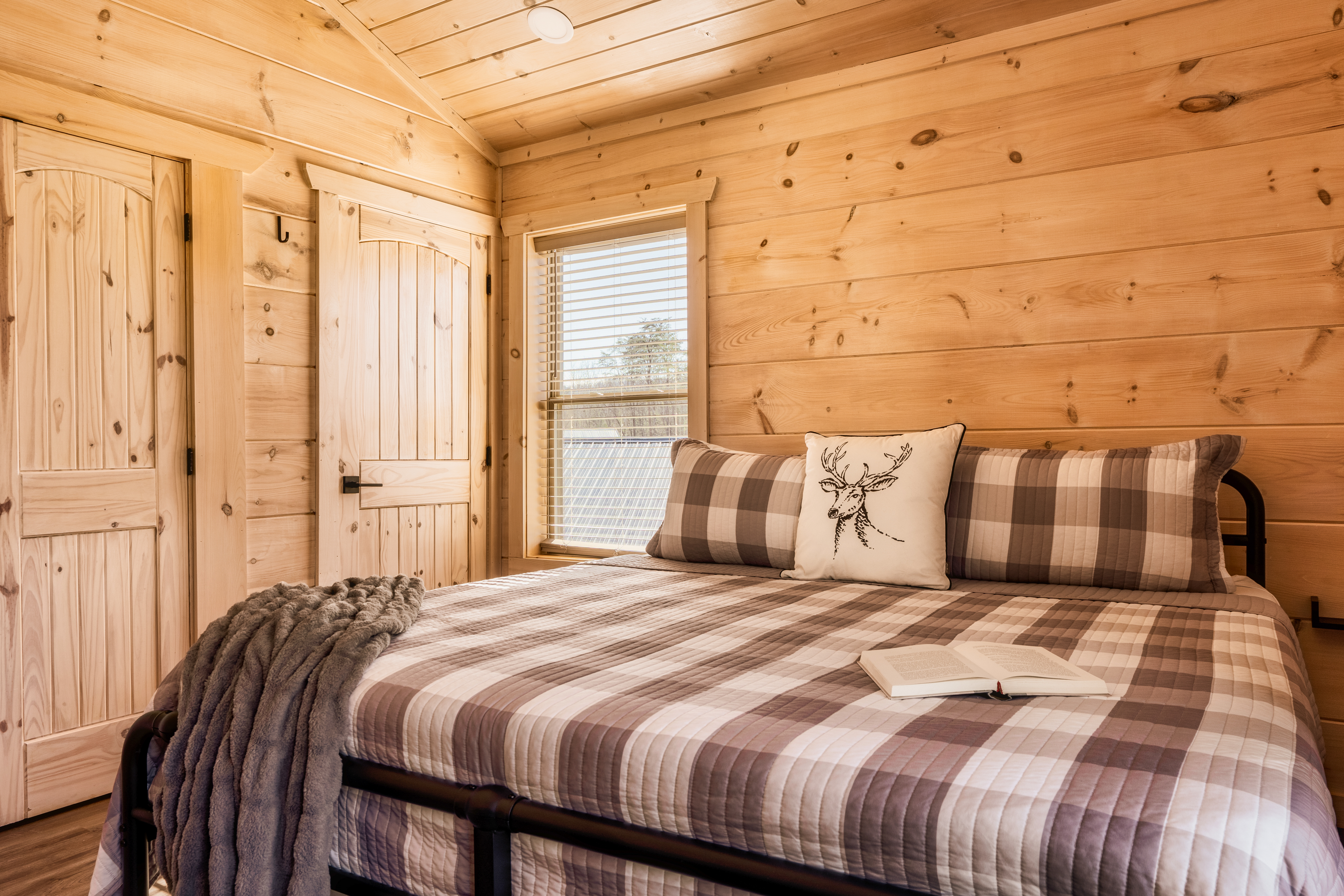 Cozy rustic cabin bedroom with warm wood interiors and plush king bed