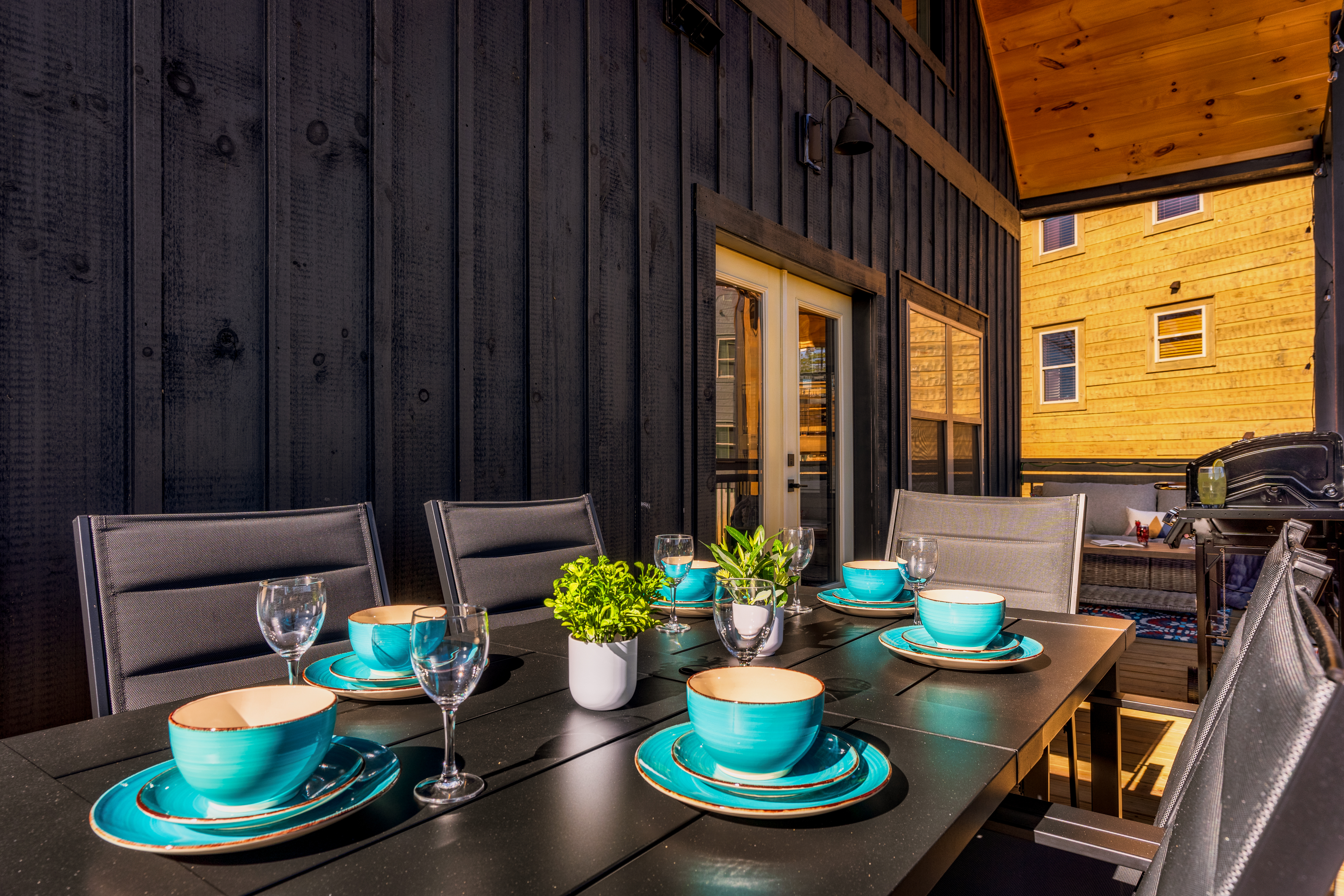 Covered patio dining with grill and stylish outdoor seating