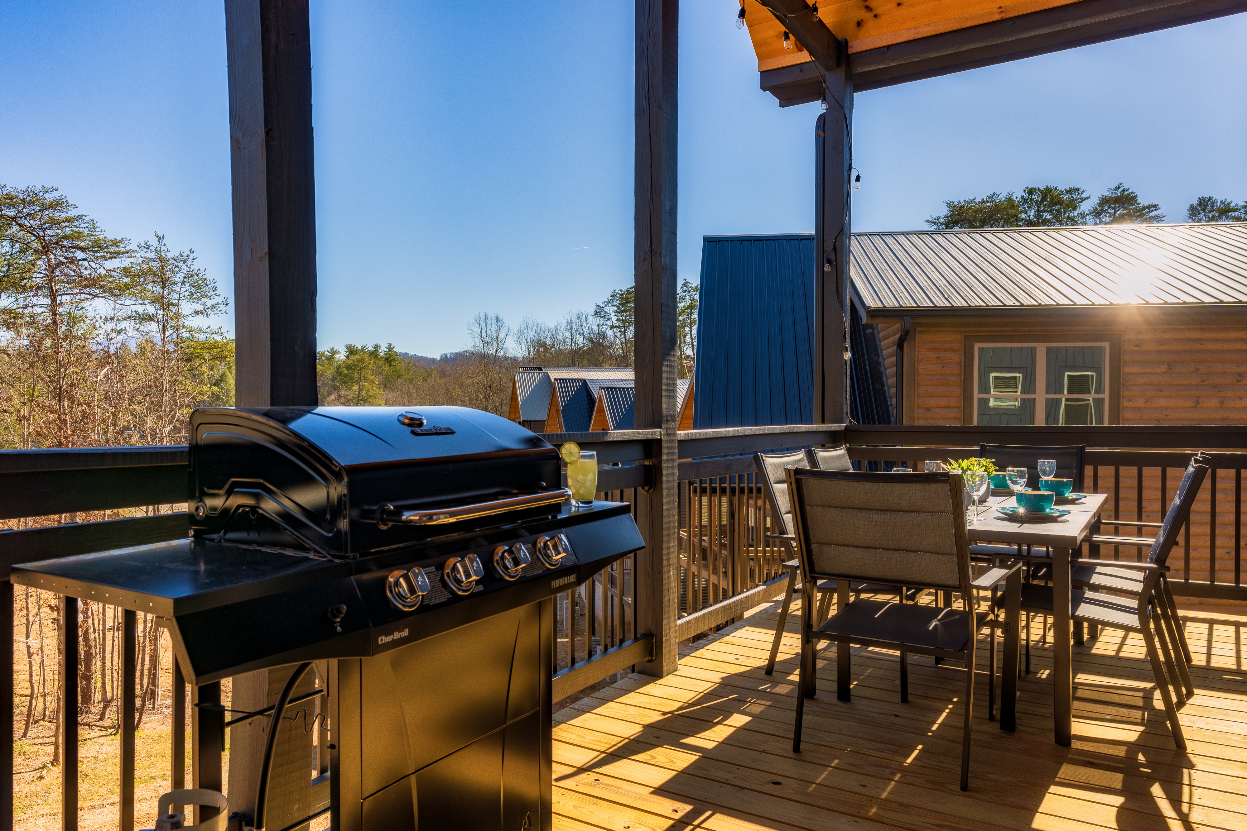 Covered deck with grill and sunny outdoor dining for four
