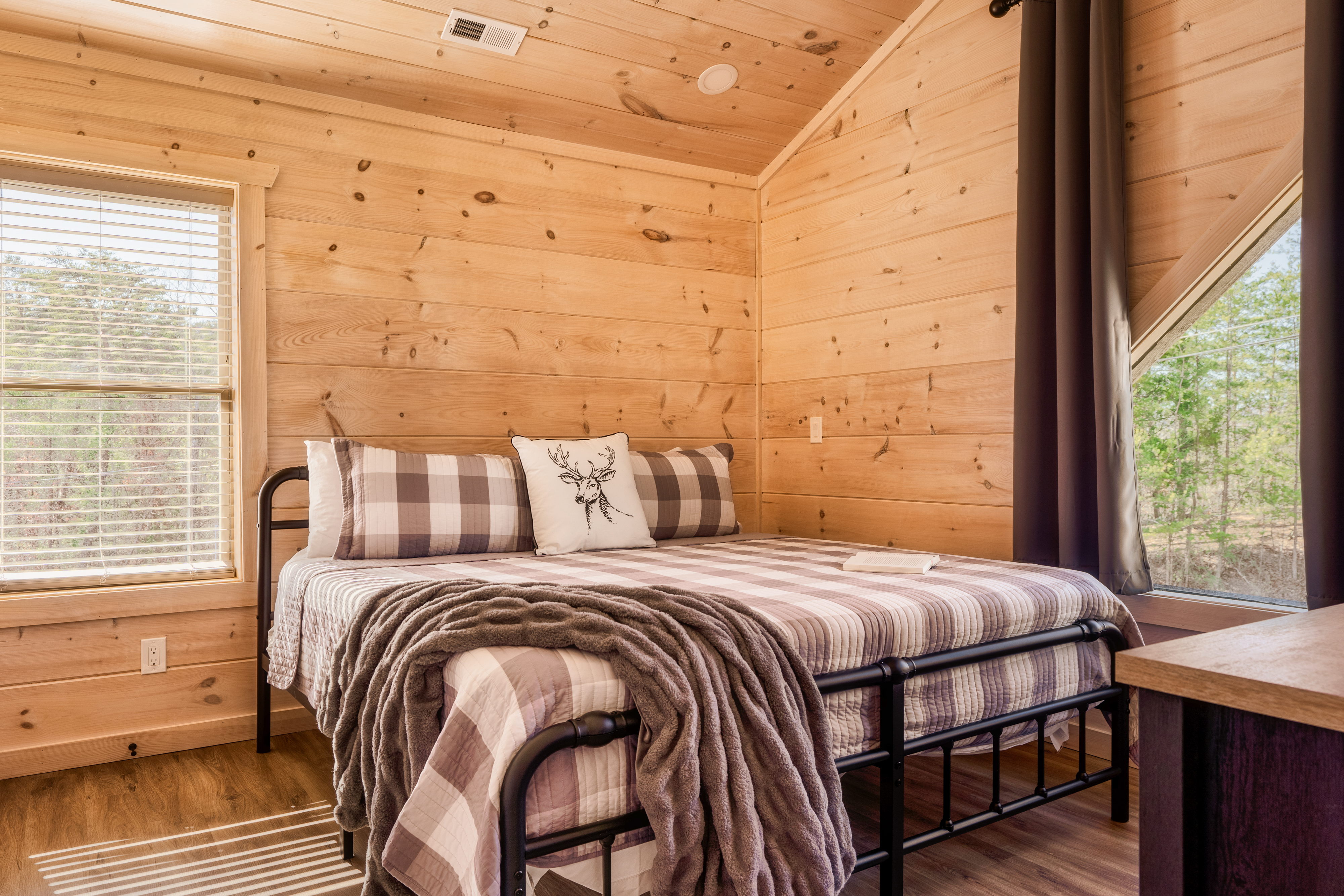 Cozy cabin bedroom with woodland views and warm rustic charm