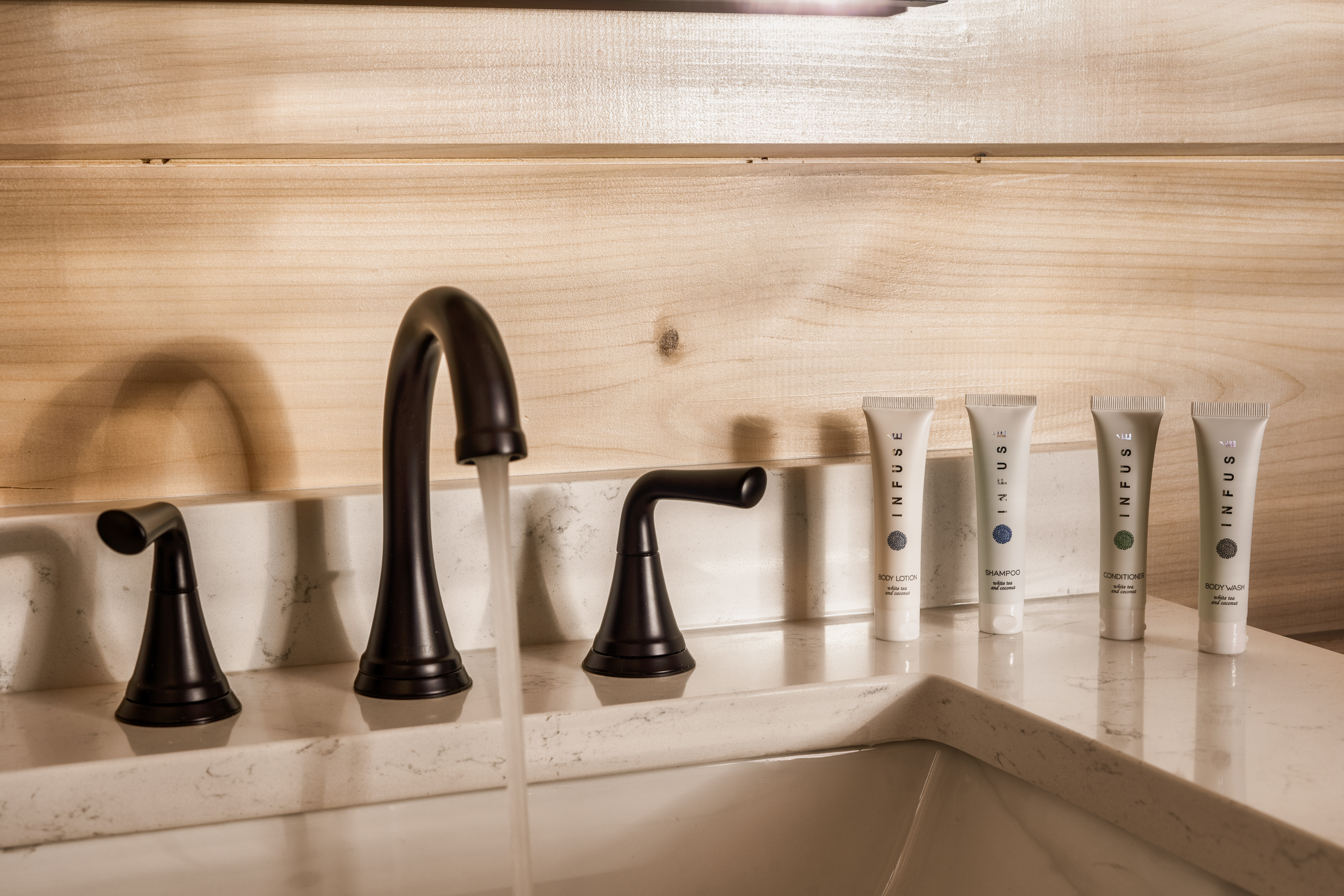 Stylish bath vanity with premium toiletries and warm modern finishes