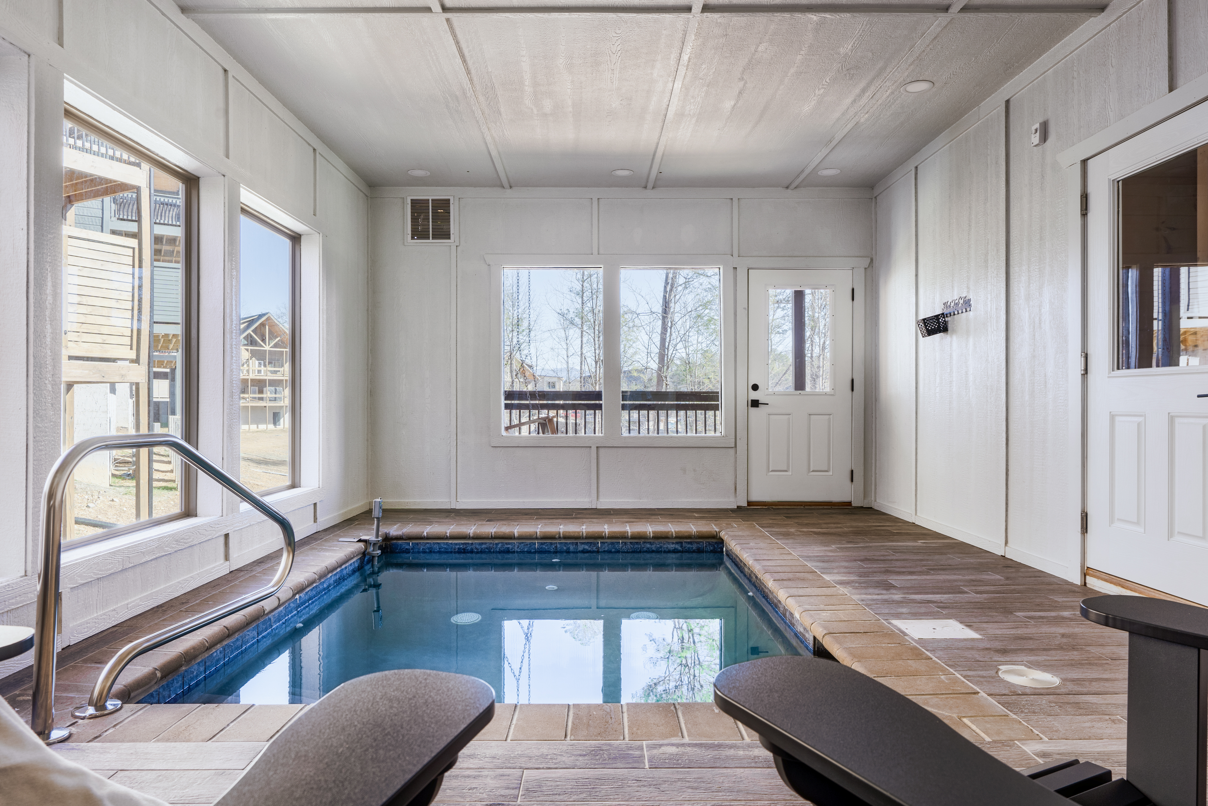 Private indoor plunge pool with lounge seating and bright natural light