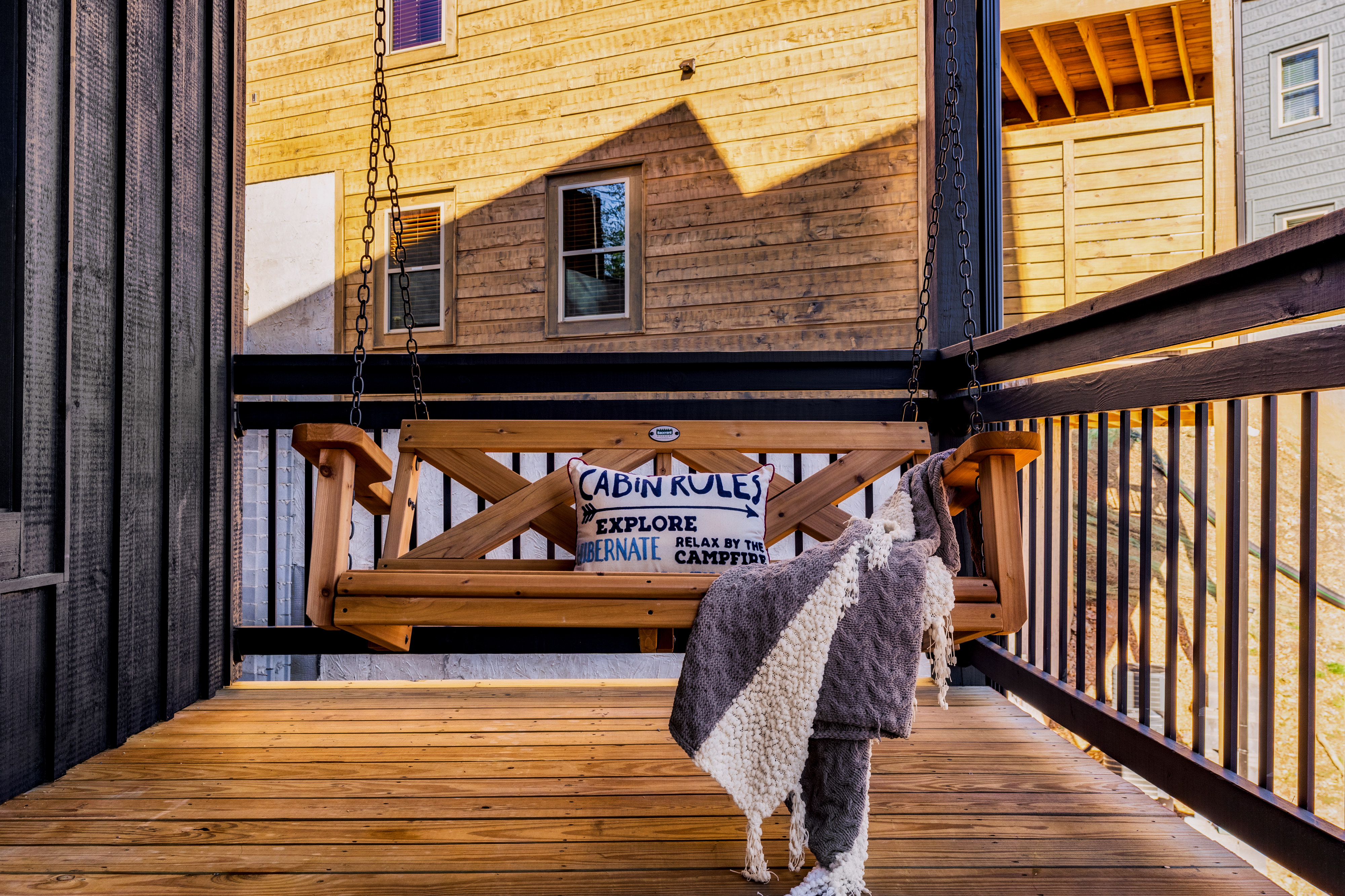 Cozy covered balcony with porch swing and rustic cabin charm