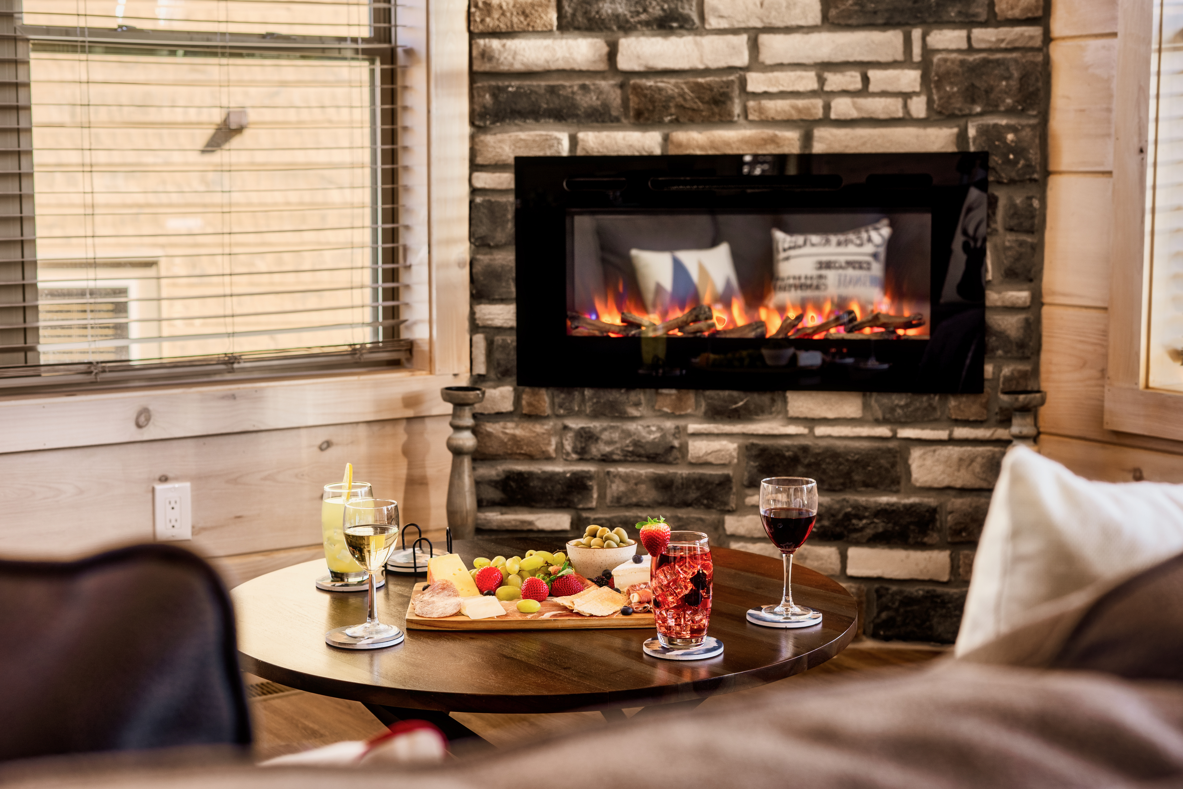 Cozy fireside nook with wine, charcuterie, and rustic cabin charm