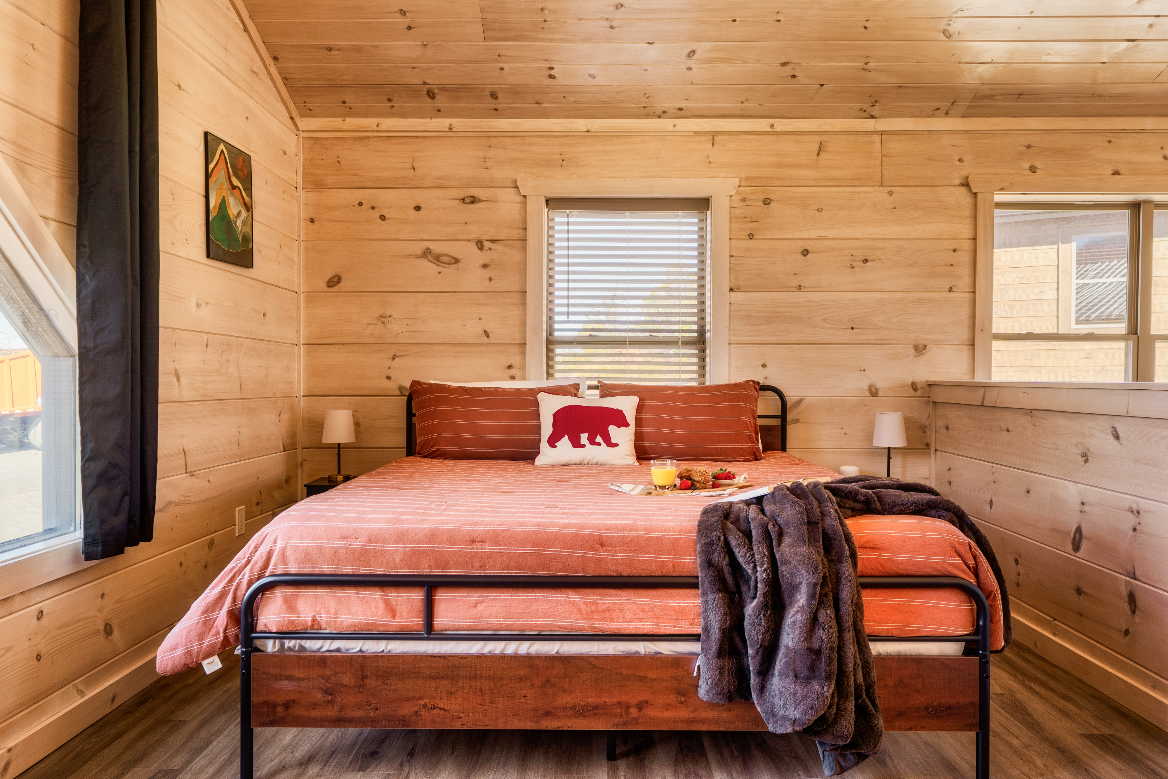 Cozy wood-paneled bedroom with warm cabin charm and natural light
