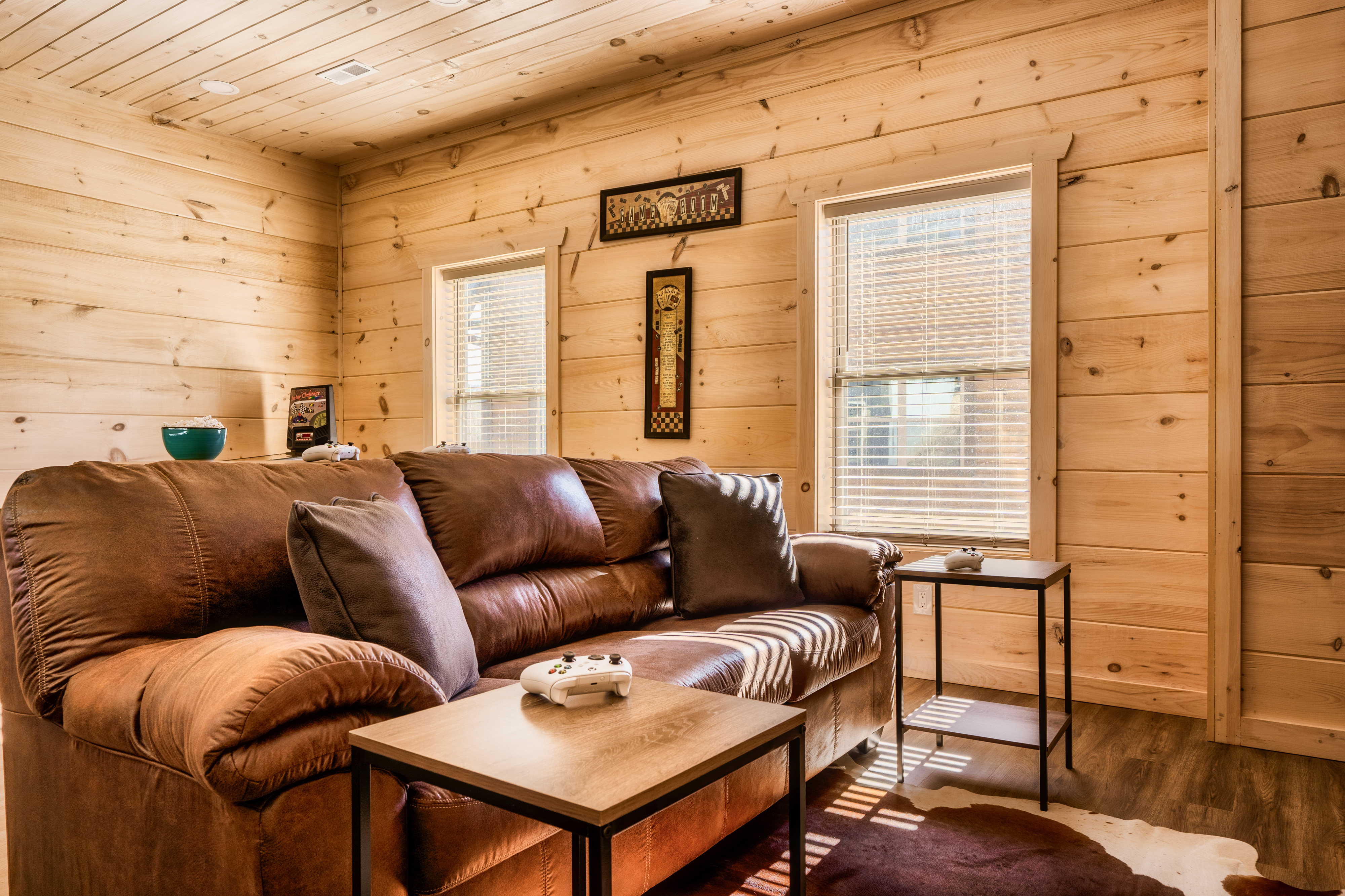 Cozy cabin lounge with leather sofa, natural light, and rustic charm
