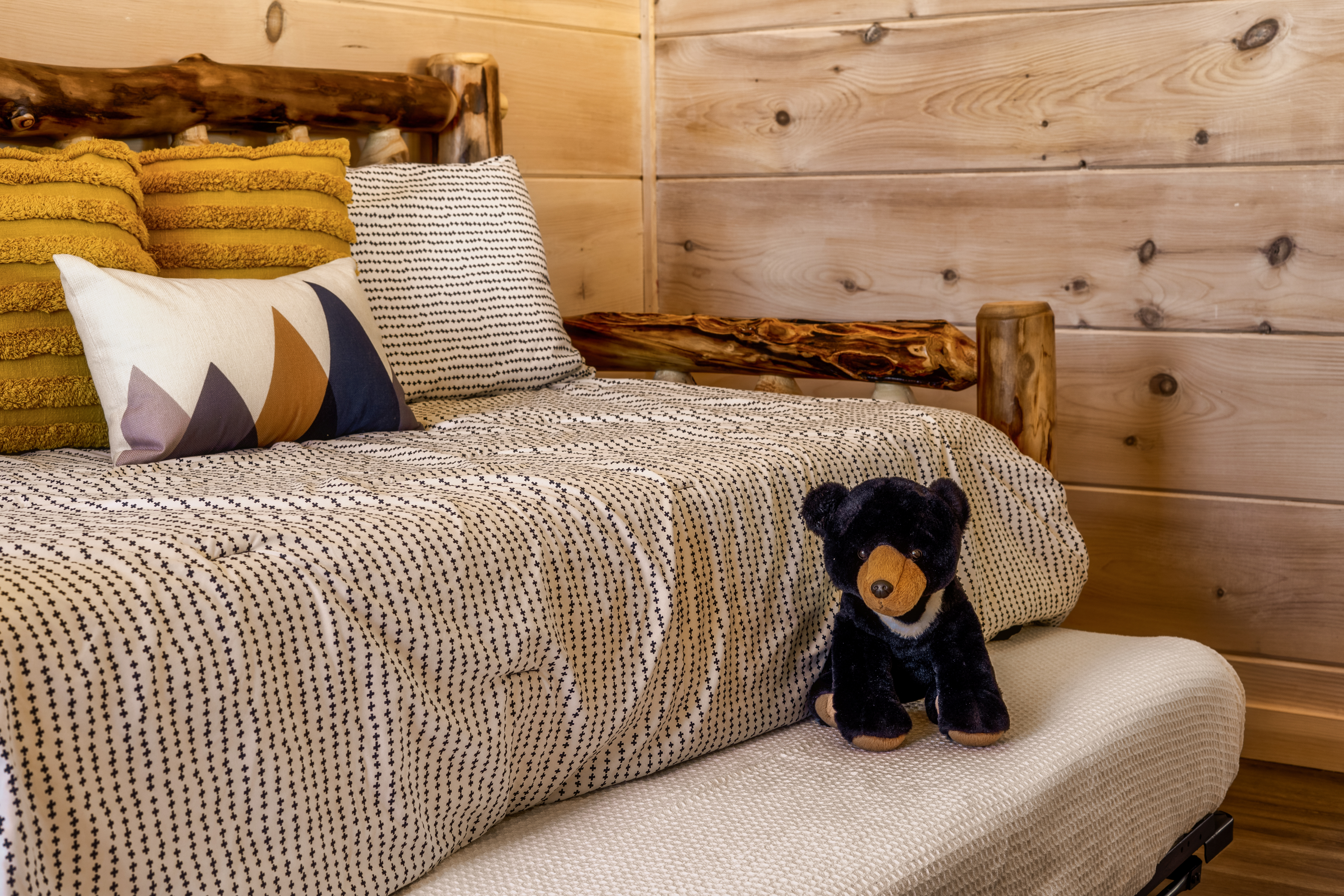 Cozy rustic cabin bedroom with log bed and warm, inviting details