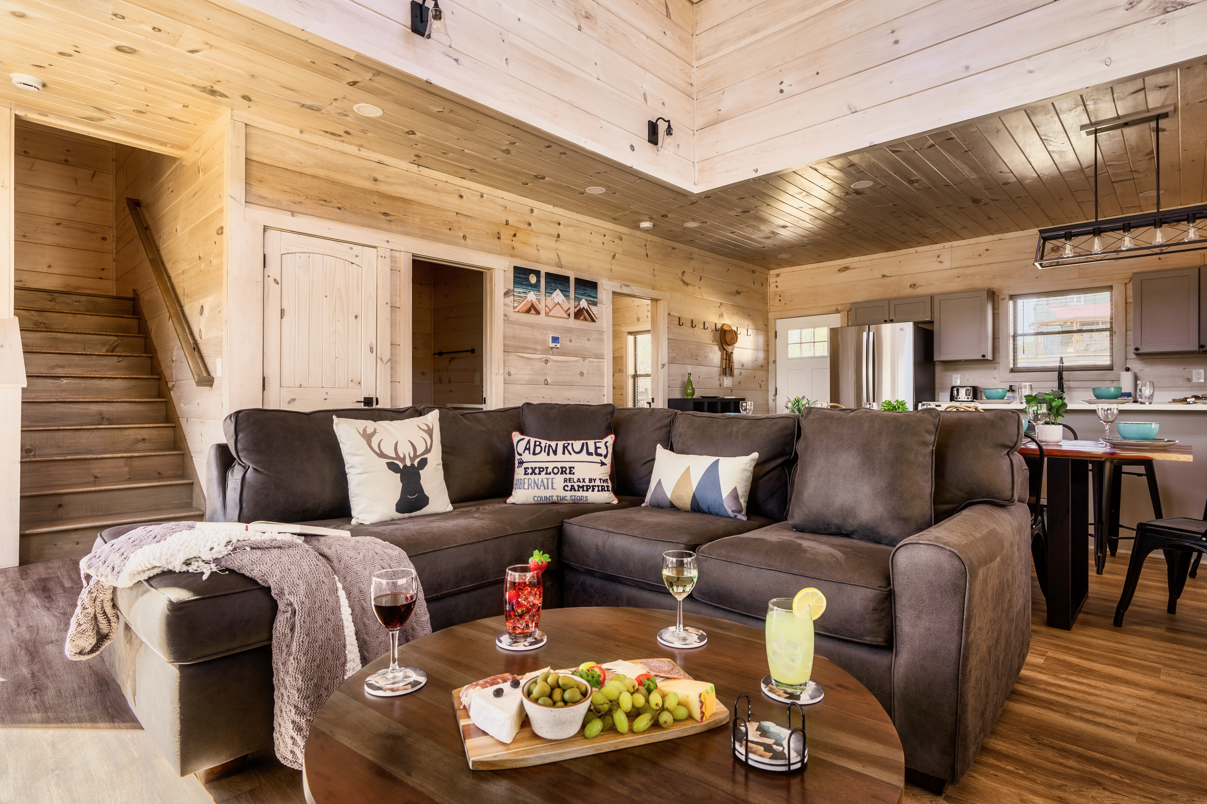 Cozy cabin-style lounge with spacious sectional and open kitchen