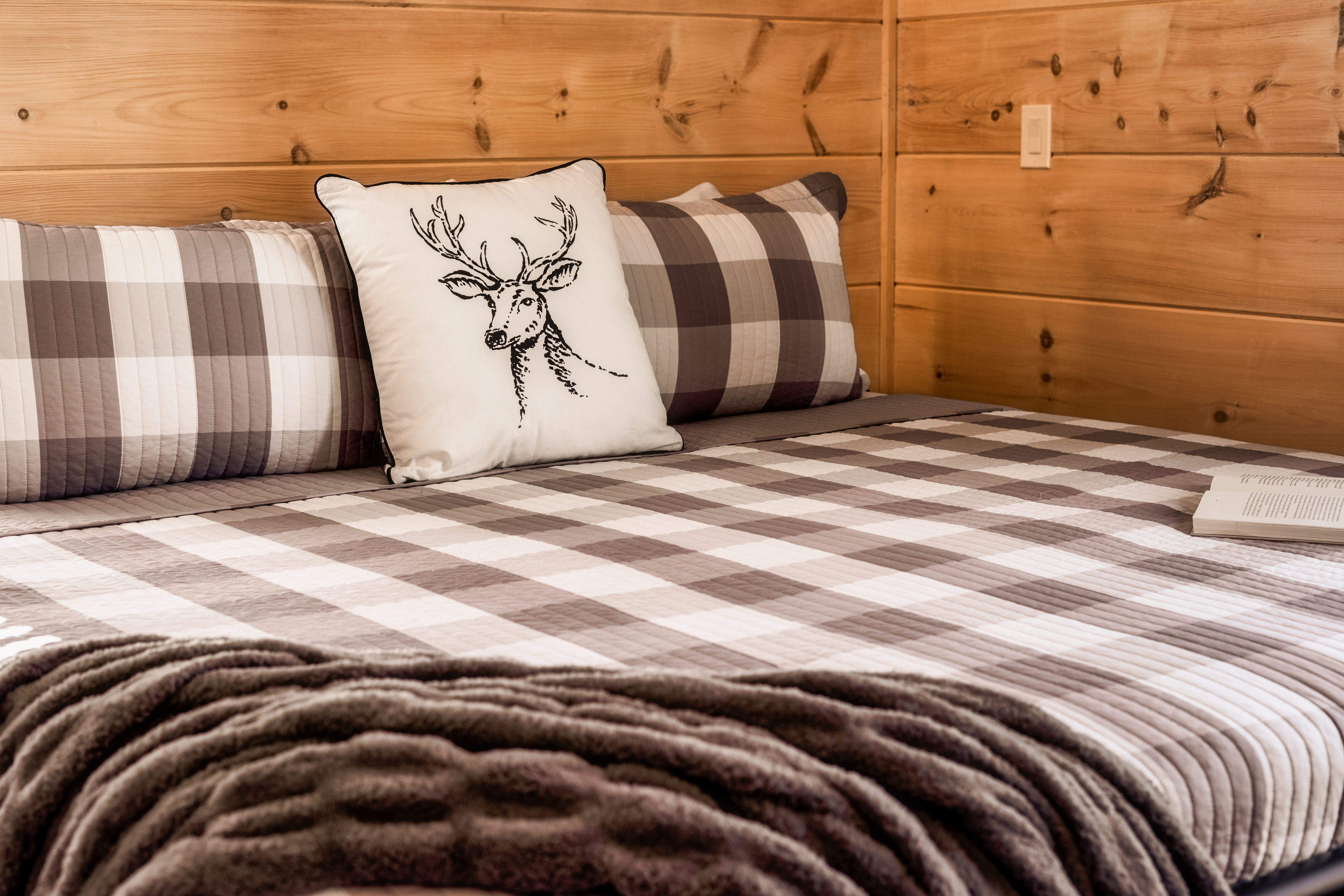 Cozy cabin-style bedroom with plaid bedding and rustic wood charm