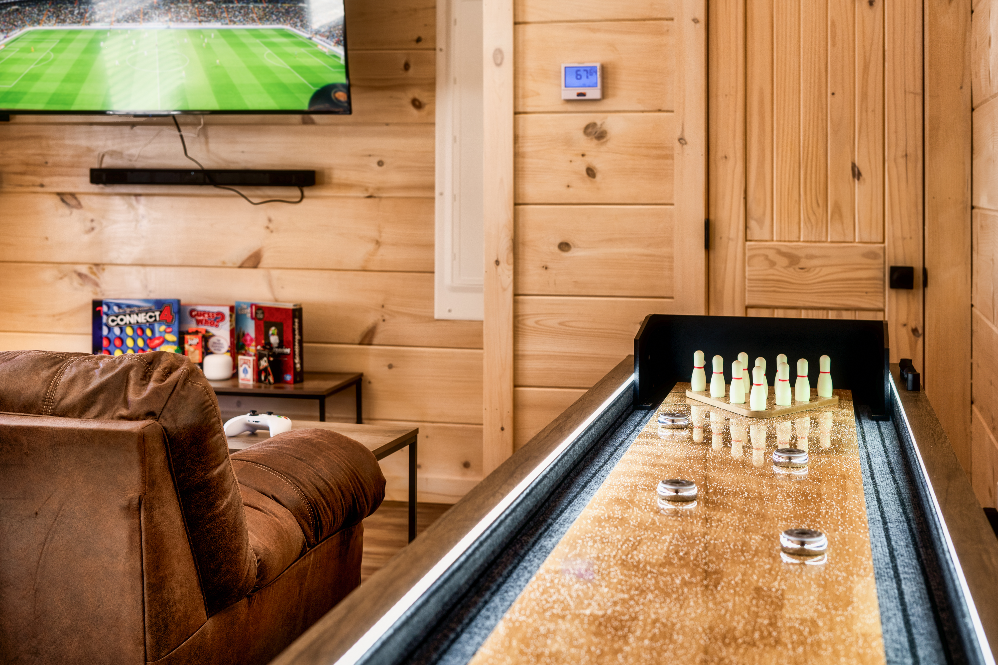 Cozy cabin game room with shuffleboard, TV, and family-friendly fun