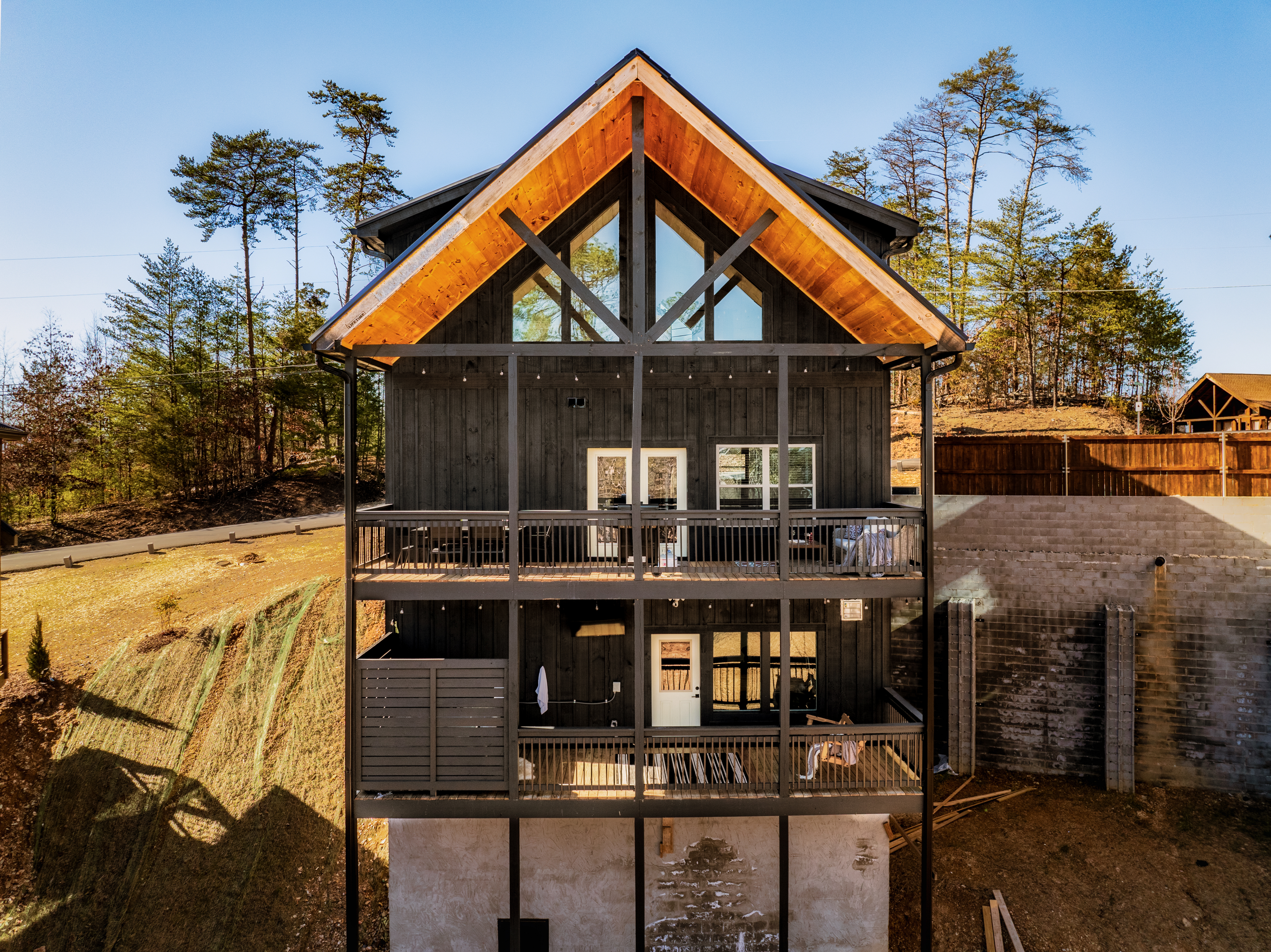 Modern A-frame retreat with covered decks and wooded hillside views