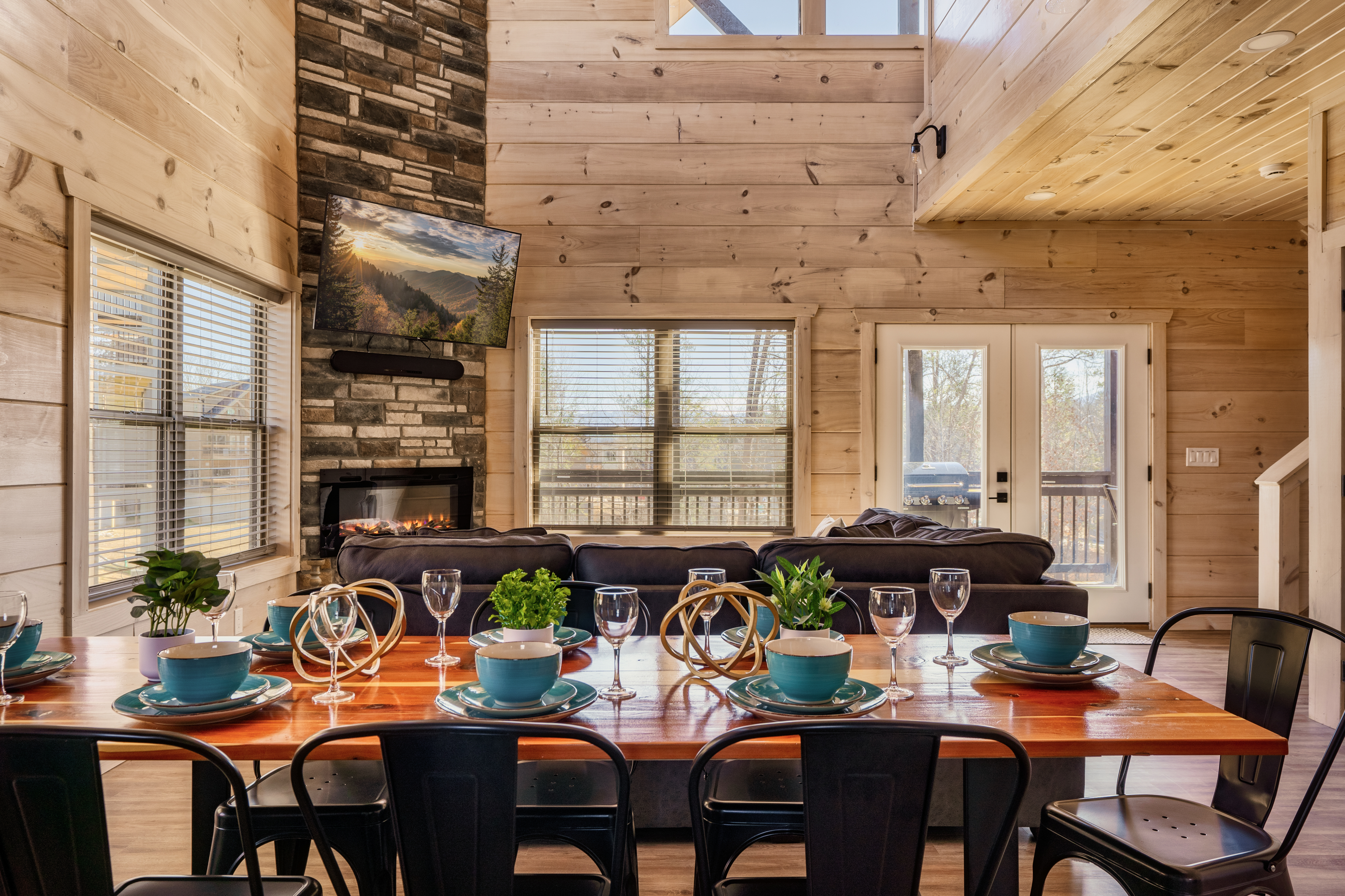 Rustic-chic great room with stone fireplace, deck access, and dining for 8