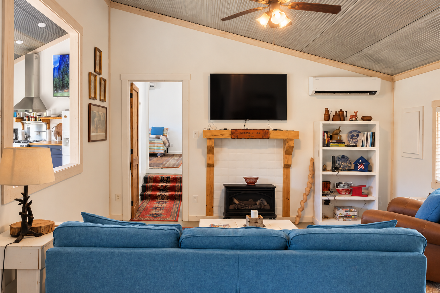 Cozy living room with fireplace, TV, vaulted ceiling, and stylish seating
