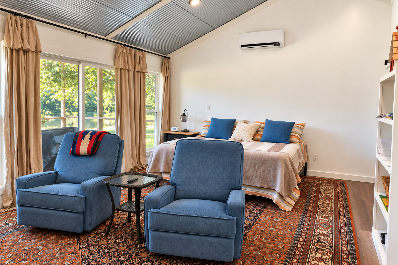 Sunny king bedroom with cozy seating and peaceful outdoor views