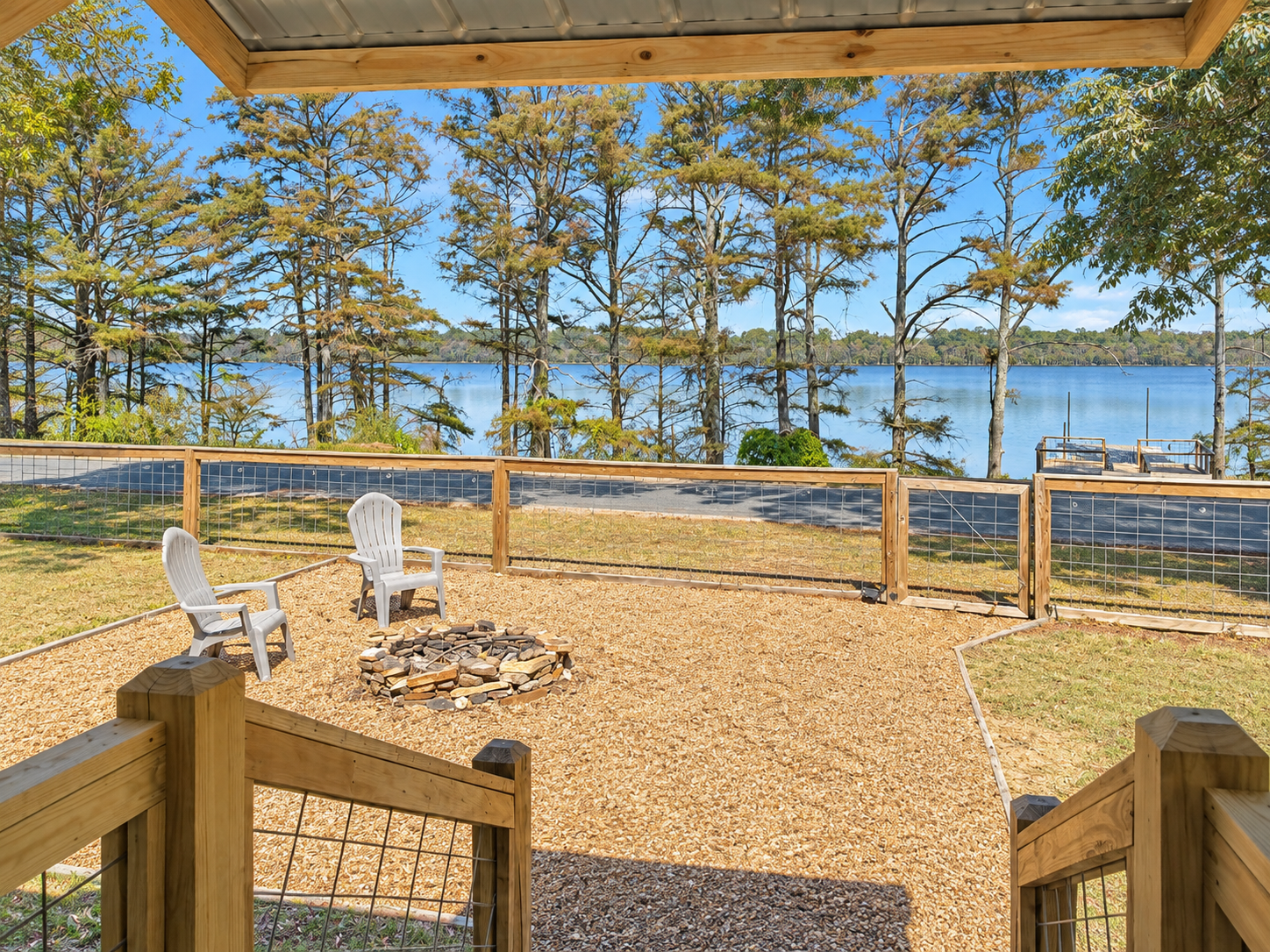Lakeside fire pit patio with Adirondack chairs and peaceful water views