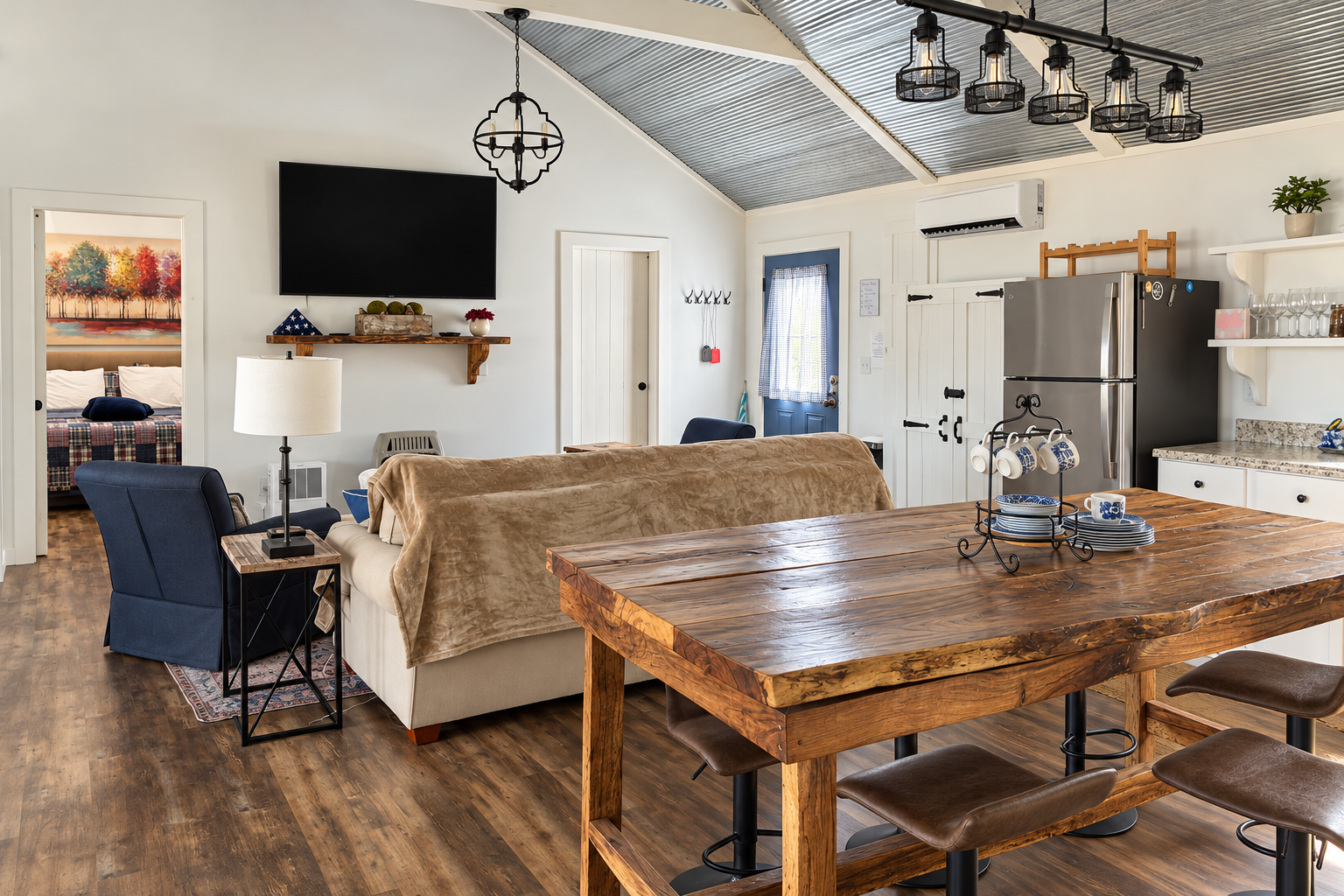Bright open living space with vaulted ceilings, dining table, and full kitchen