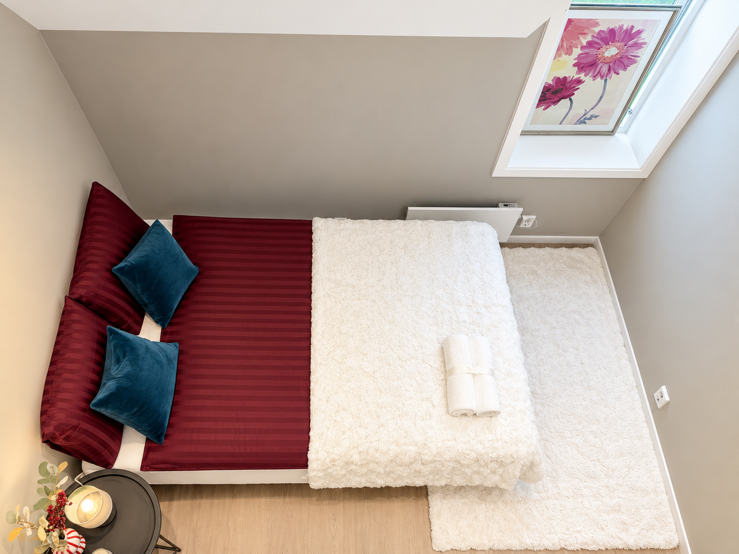 Cozy skylit bedroom with plush bedding and stylish modern touches