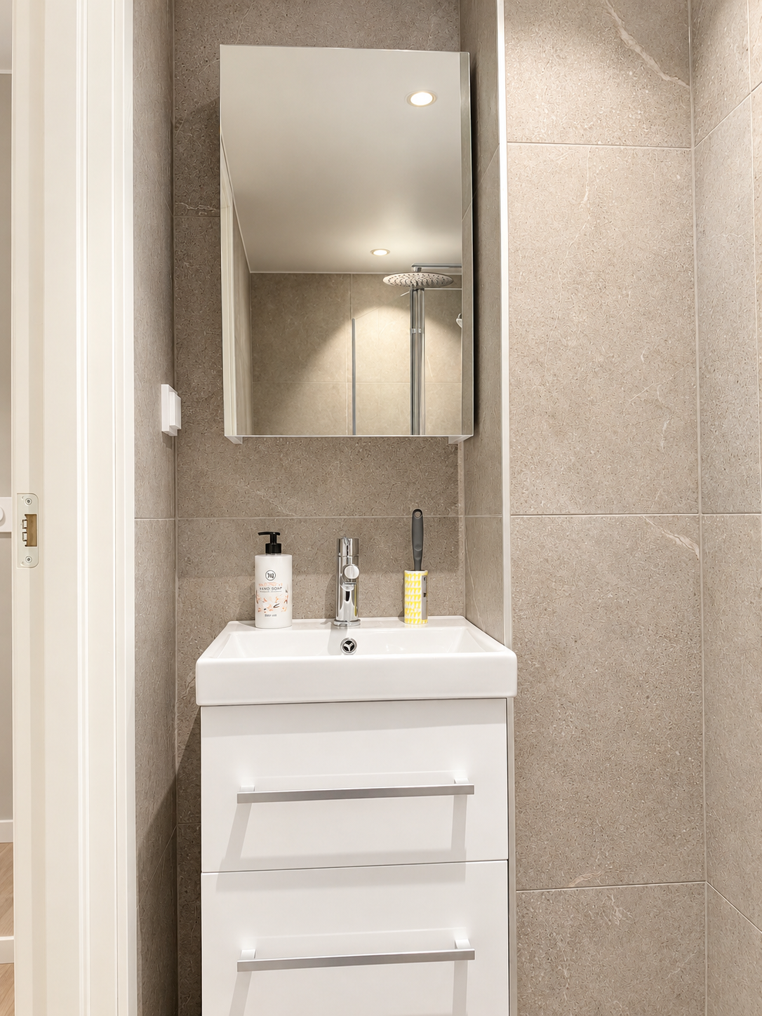 Modern tiled bathroom with sleek vanity and mirrored cabinet