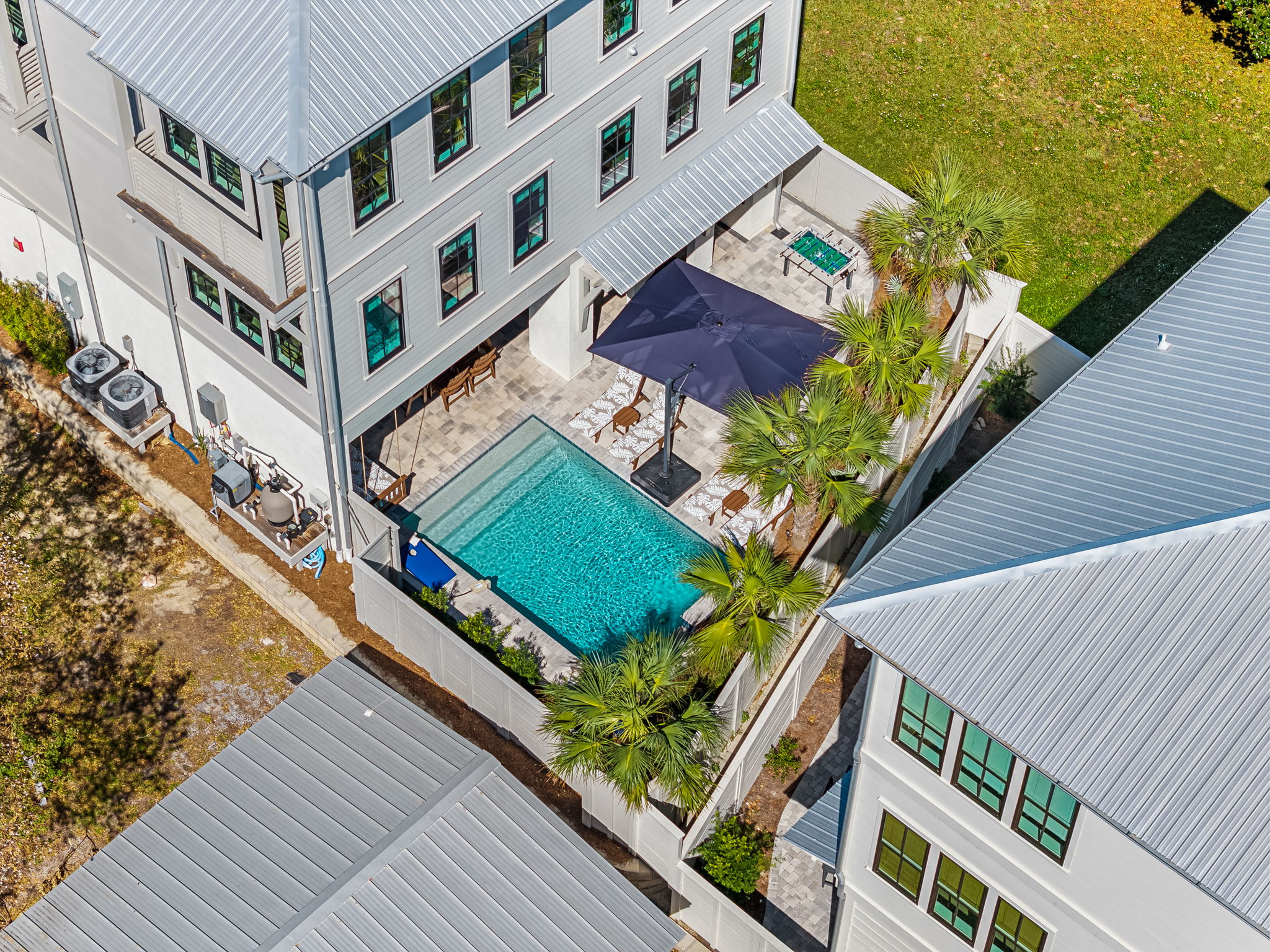 Private courtyard pool with tropical palms and shaded lounge seating
