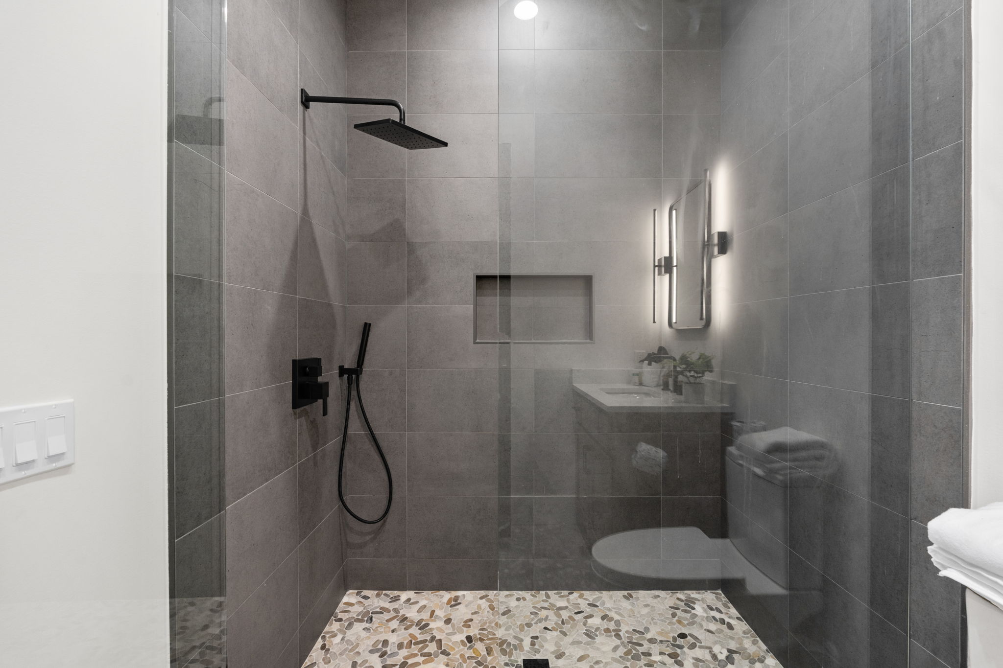 Modern spa-style bathroom with walk-in rain shower and sleek finishes